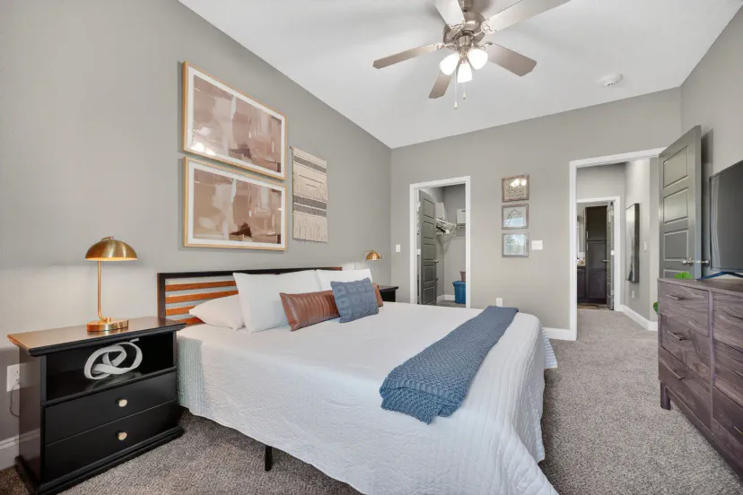Spacious king bedroom with stylish decor, TV, and cozy modern touches