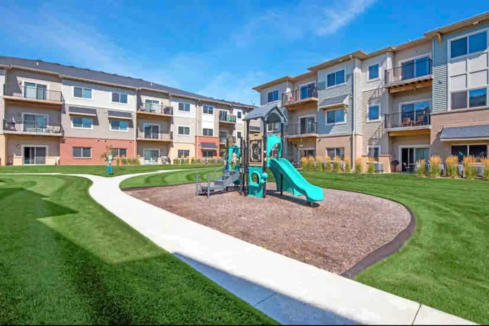 Community playground just steps away — a safe, well-maintained play area with open green space, perfect for kids to burn off energy while adults relax nearby.
