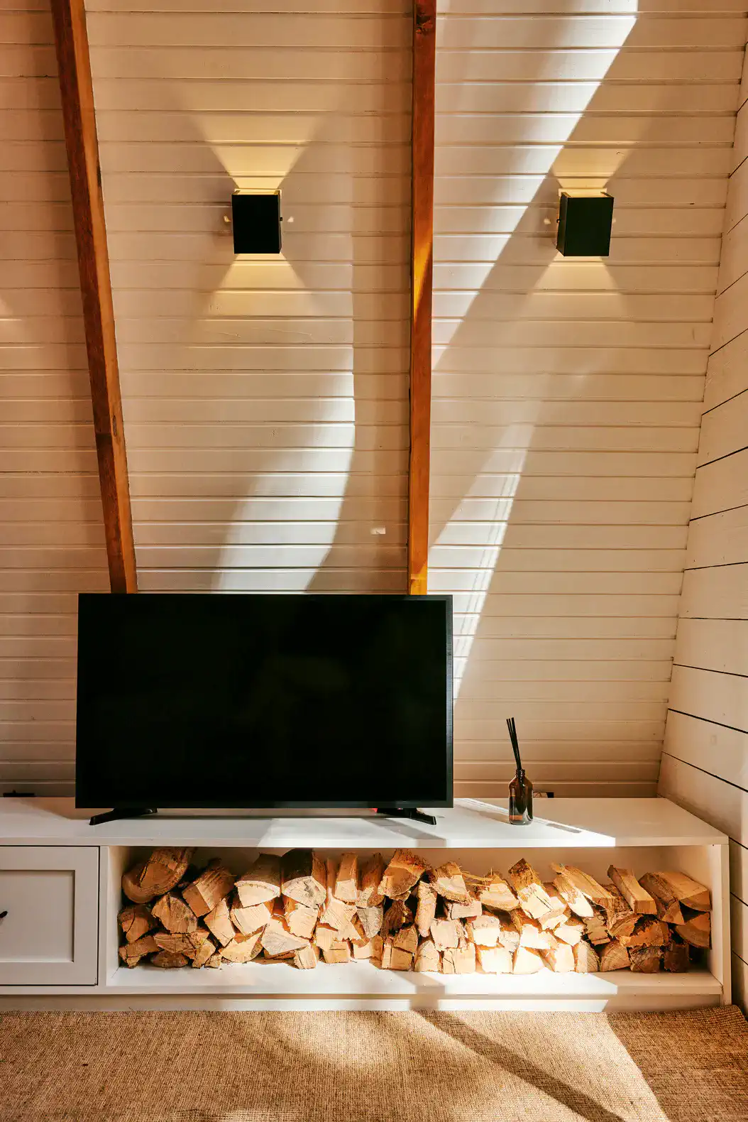 Cozy living room with a TV and a wood storage area beneath