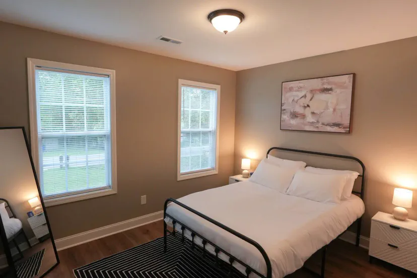 Cozy bedroom with a double bed, two windows, and modern decor