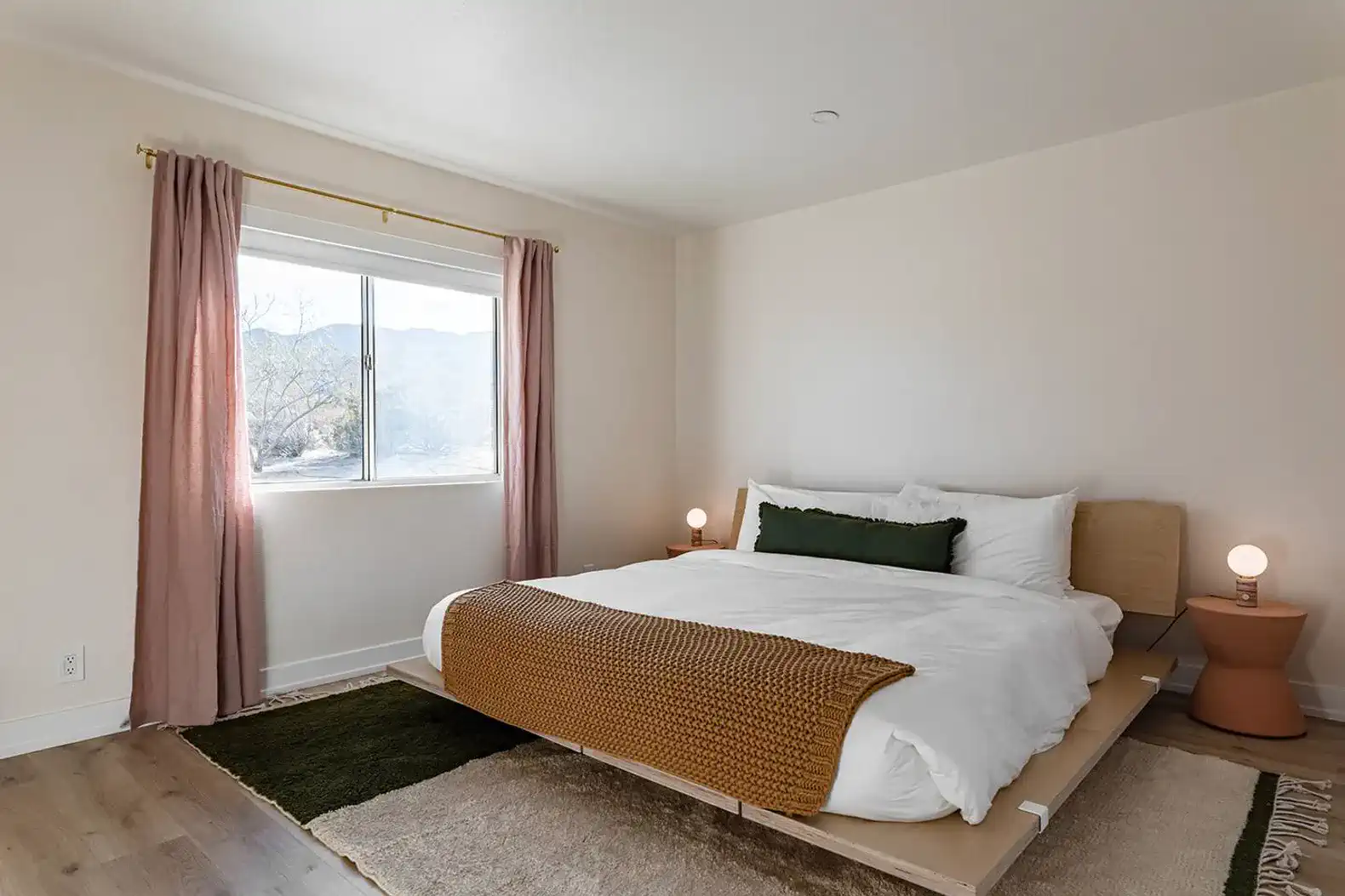 Cozy master bedroom with a large window and soft bedding