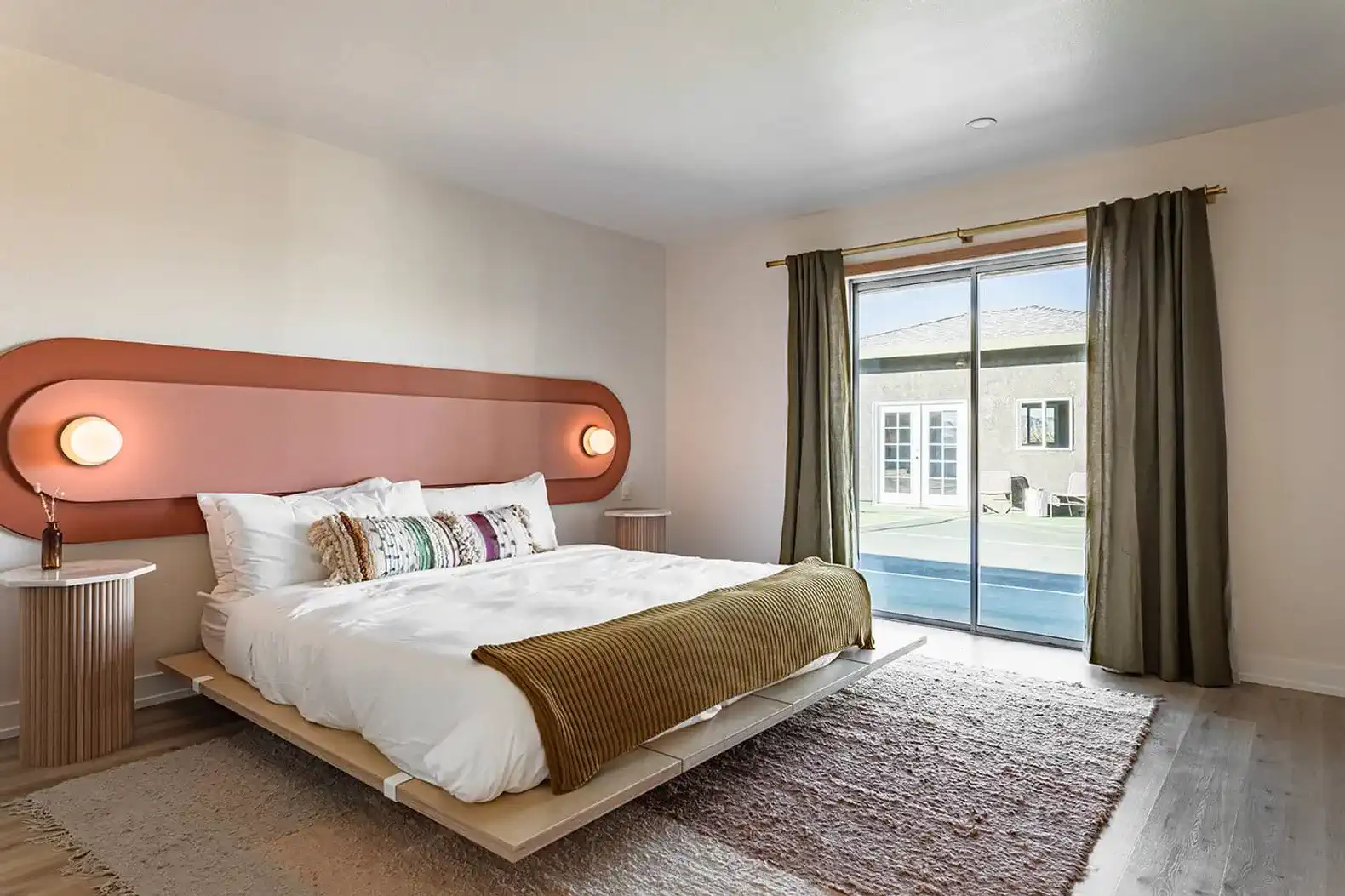 Stylish master bedroom with a large bed, modern decor, and sliding glass doors to the outside