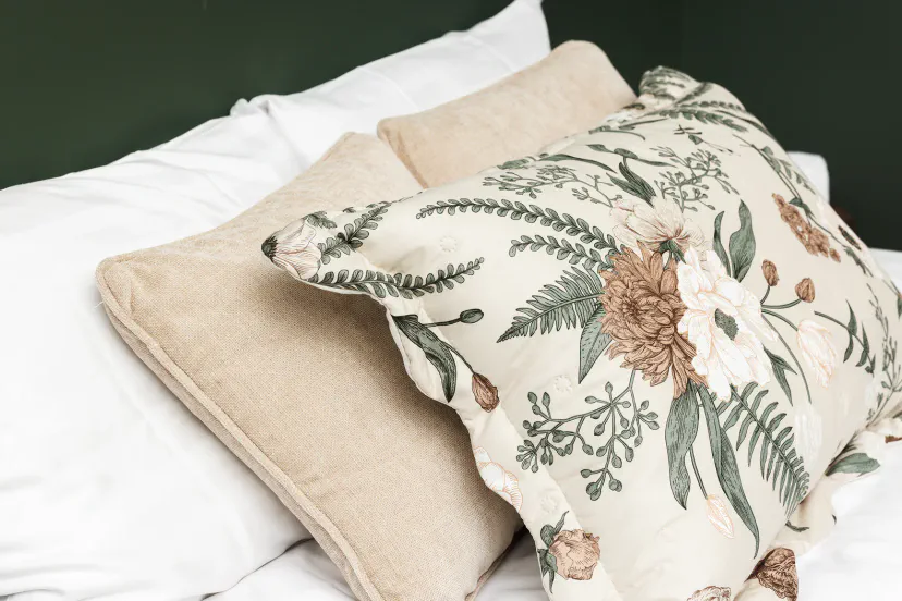 Elegant floral accent pillows on a crisp, cozy bed