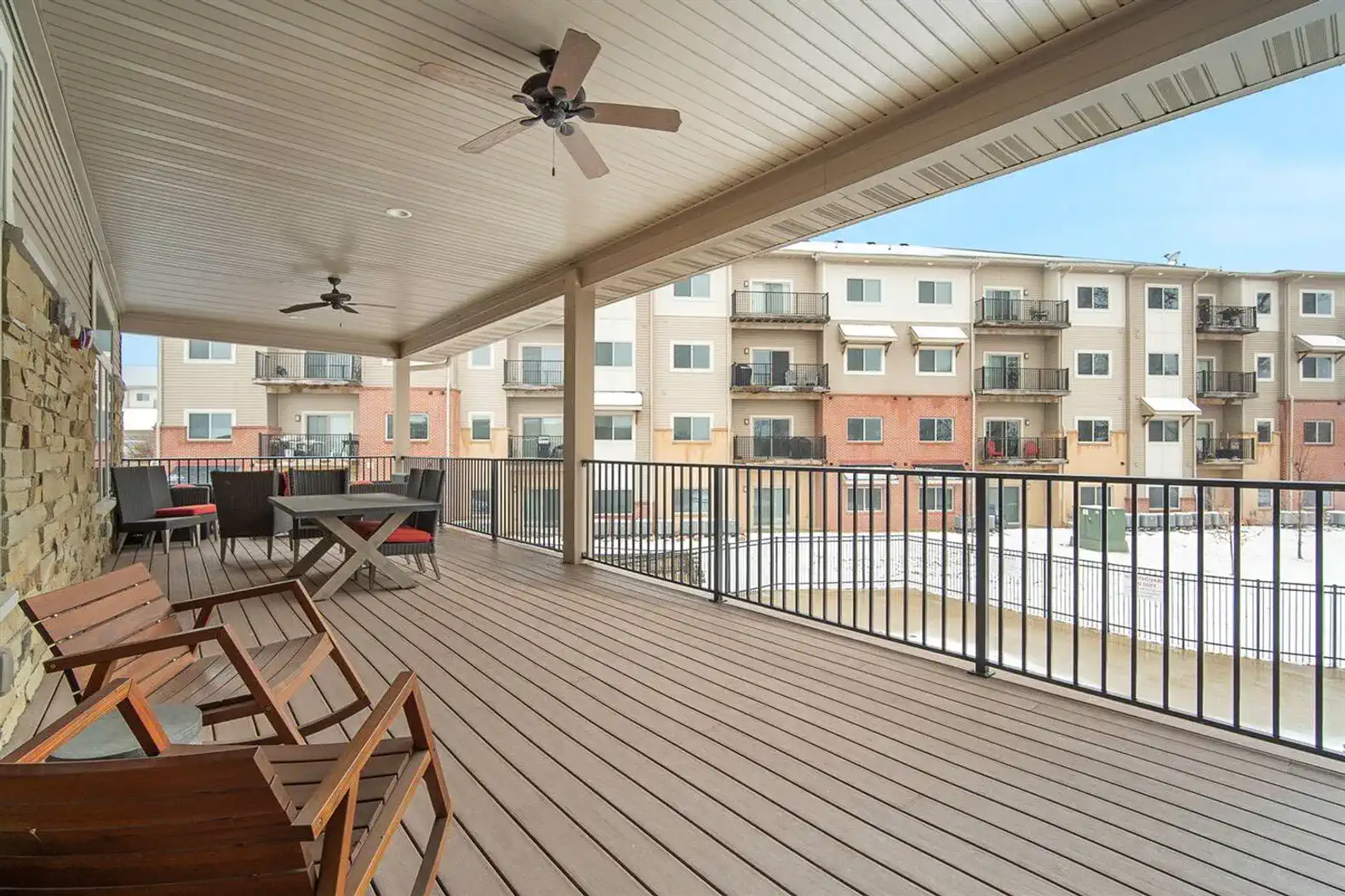 Spacious shared clubhouse deck with plenty of seating—perfect for relaxing, working outdoors, or gathering with friends. A great spot to enjoy fresh air and unwind just steps from your stay.