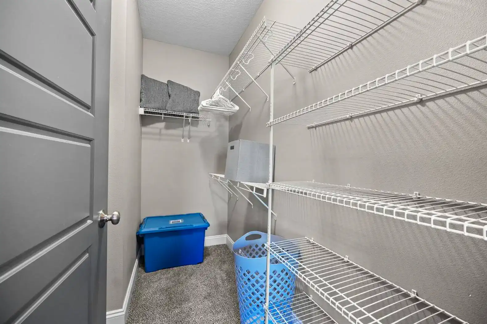 Spacious walk-in closet with shelving, hangers, extra linens, and laundry essentials—plenty of room to unpack, organize, and settle in comfortably for short or extended stays.