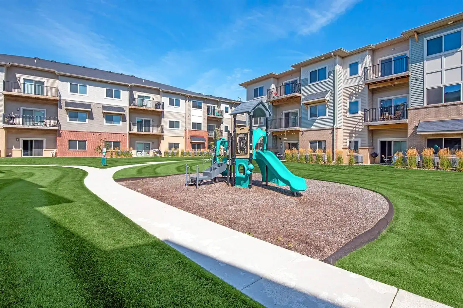 Community playground just steps away — a safe, well-maintained play area with open green space, perfect for kids to burn off energy while adults relax nearby.