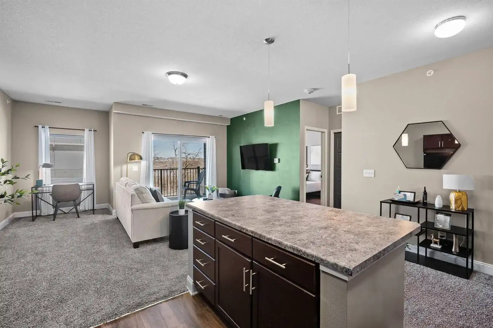Bright, open-concept living with a spacious kitchen island, cozy seating, and dedicated workspace. Natural light, modern finishes, and balcony access make this an easy place to relax, work, or unwind between plans.
