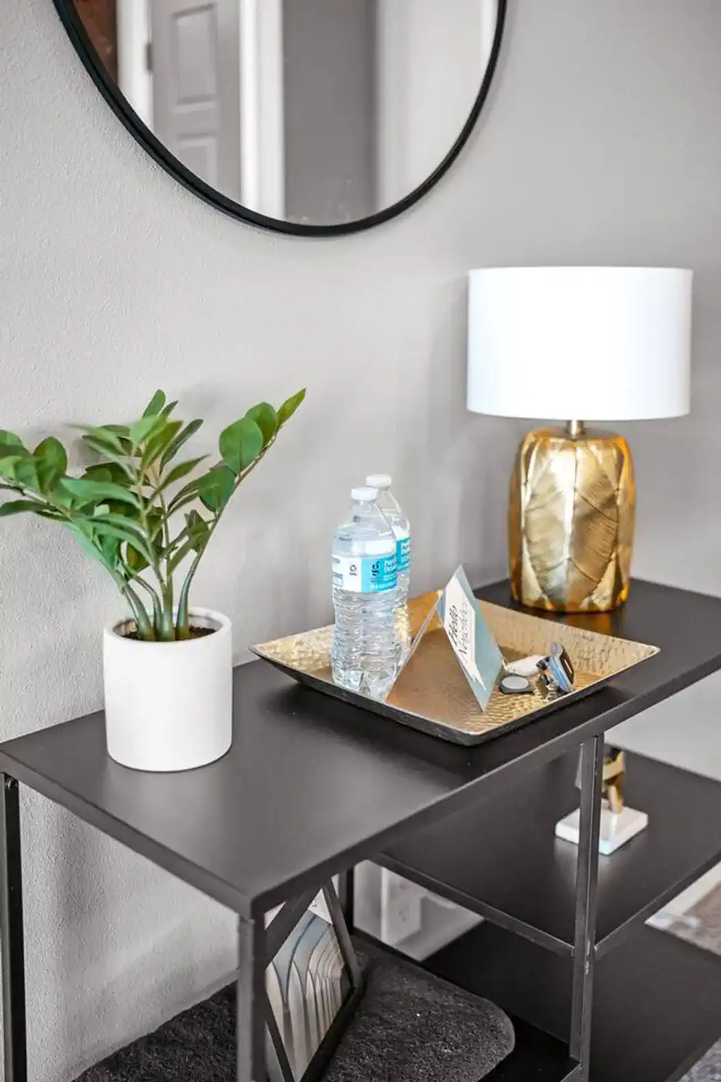 A warm welcome awaits! Enjoy complimentary bottled water, a sleek gold tray for keys and accessories, a modern lamp, and greenery that adds a fresh touch to your arrival.