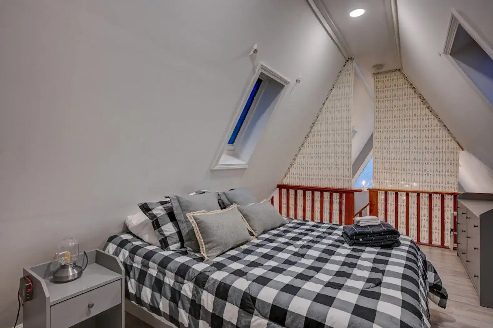 Cozy A-frame master bedroom with sloped ceilings and large windows