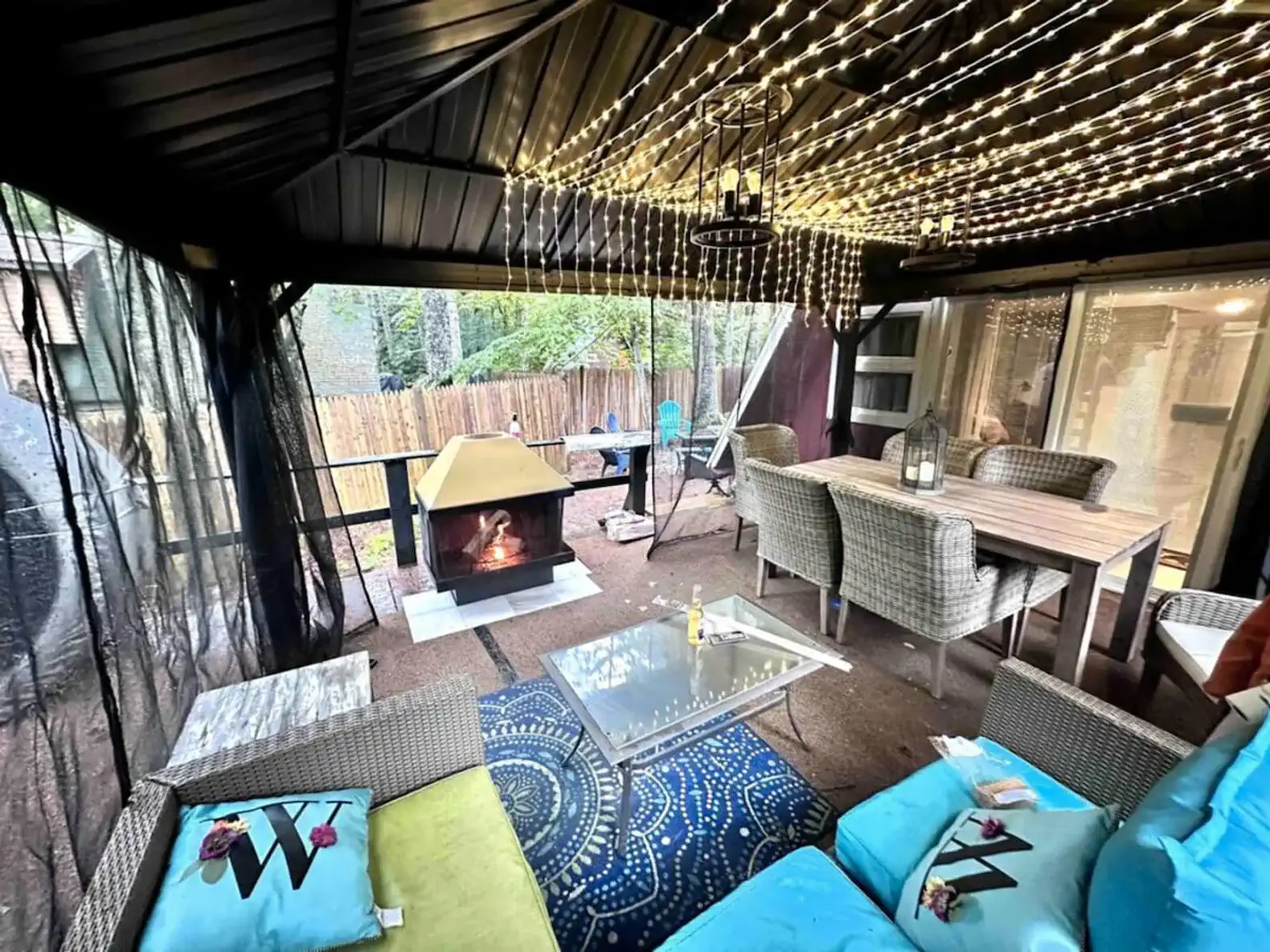 Cozy outdoor seating area with string lights and a fireplace