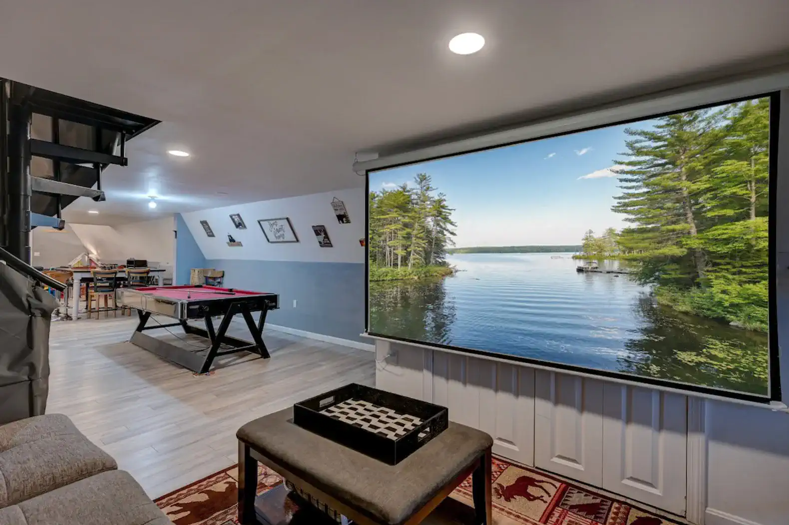 Spacious game room featuring air hockey table and large screen with lake view
