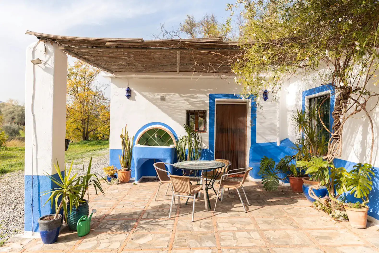 Charming outdoor patio with a round table and chairs surrounded by potted plants