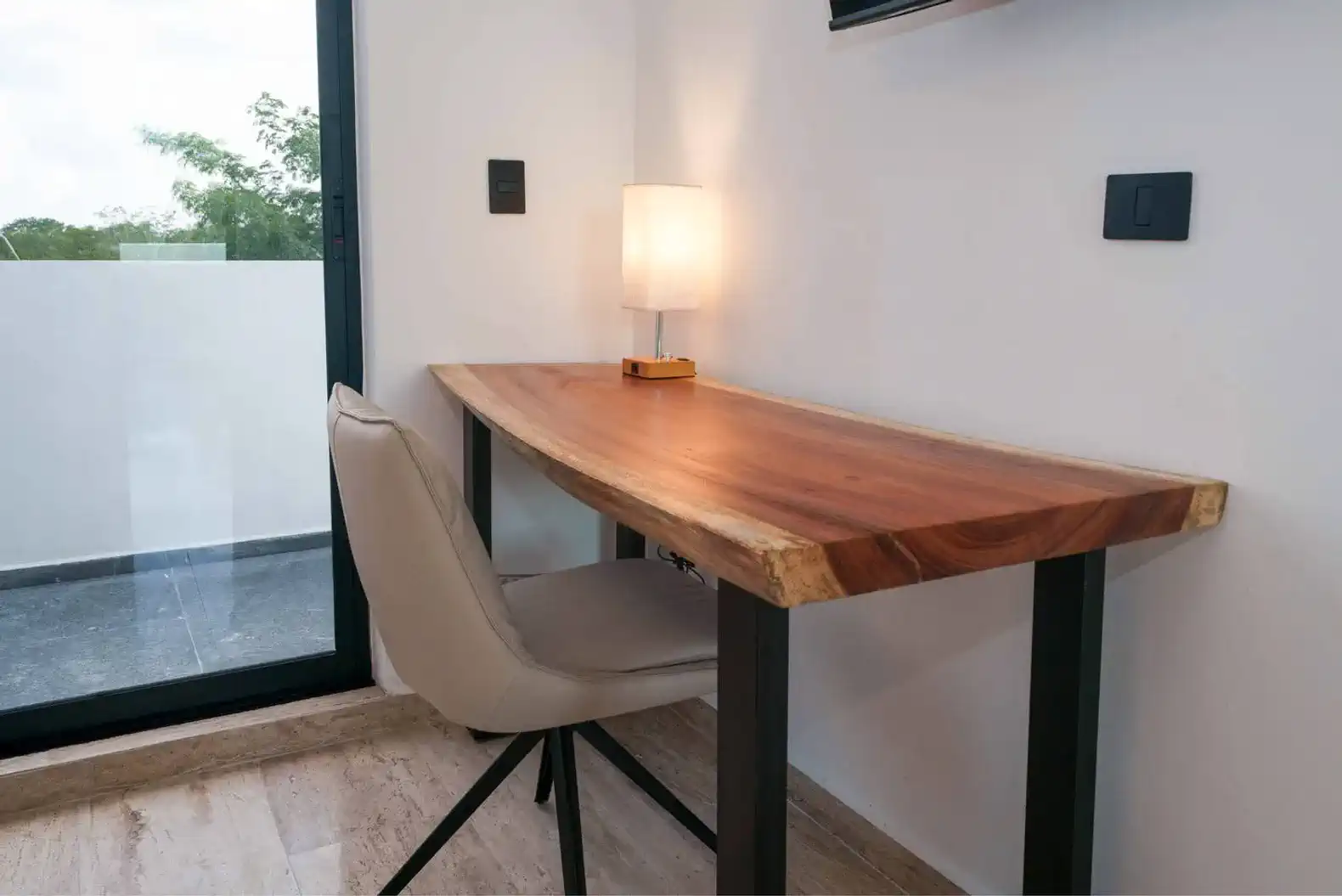 Escritorio de madera con lámpara en un ambiente luminoso