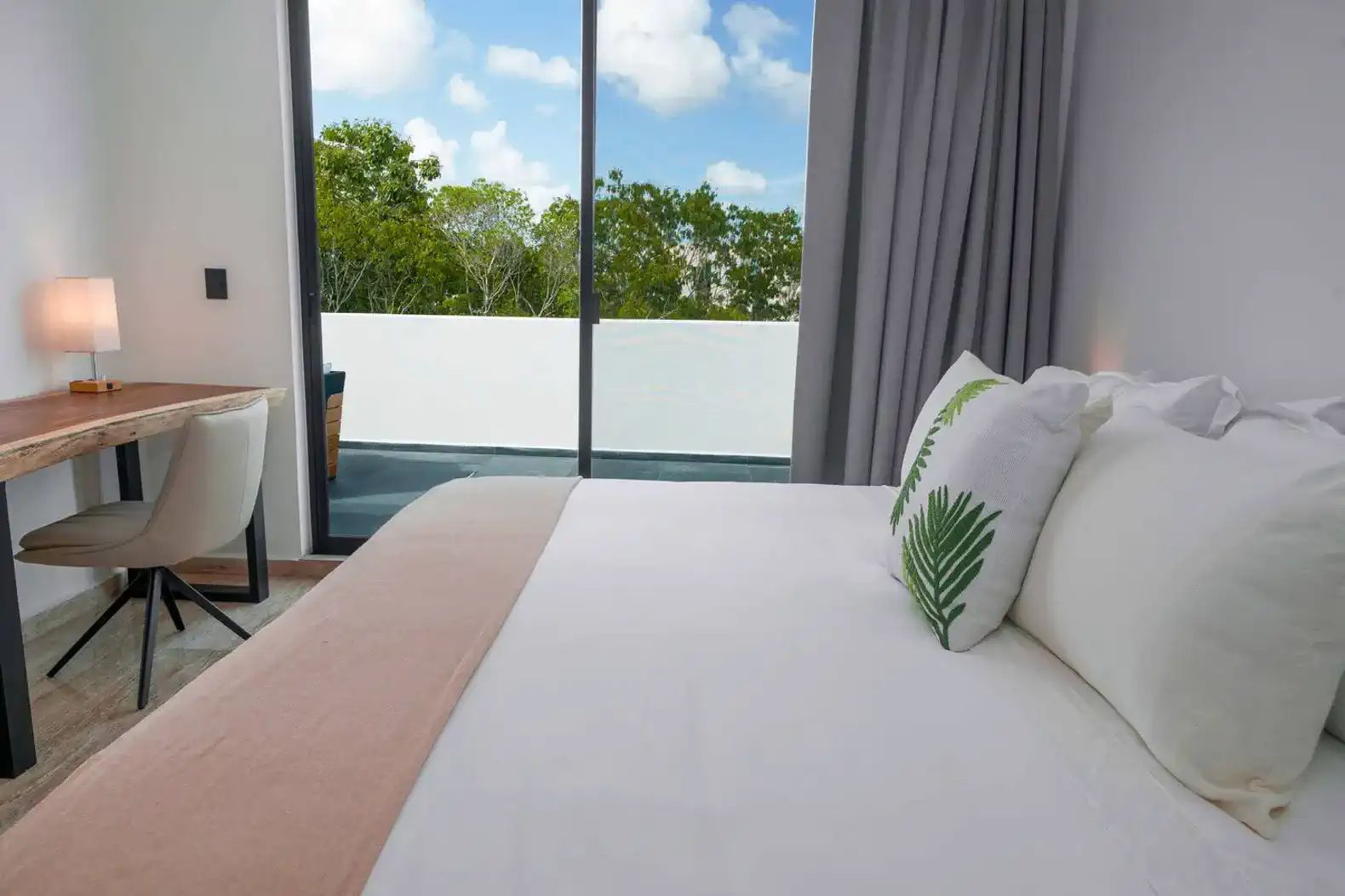 Habitación con cama cómoda, escritorio y vista al exterior