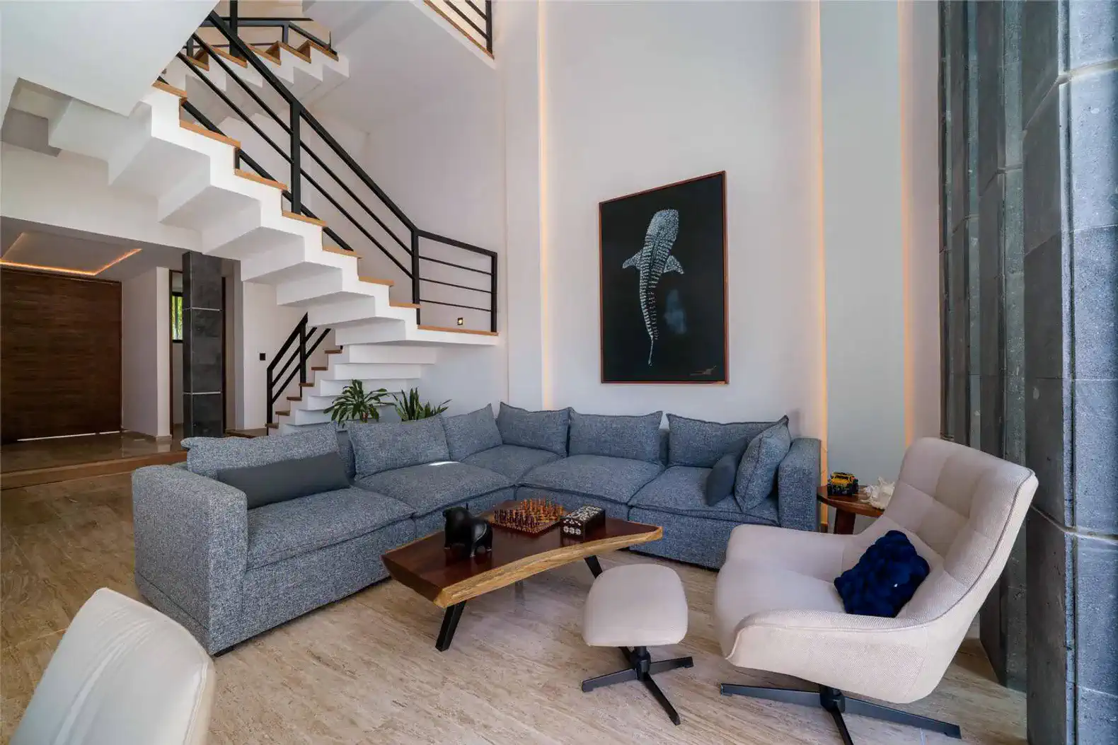 Spacious living room with modern furniture and a large staircase