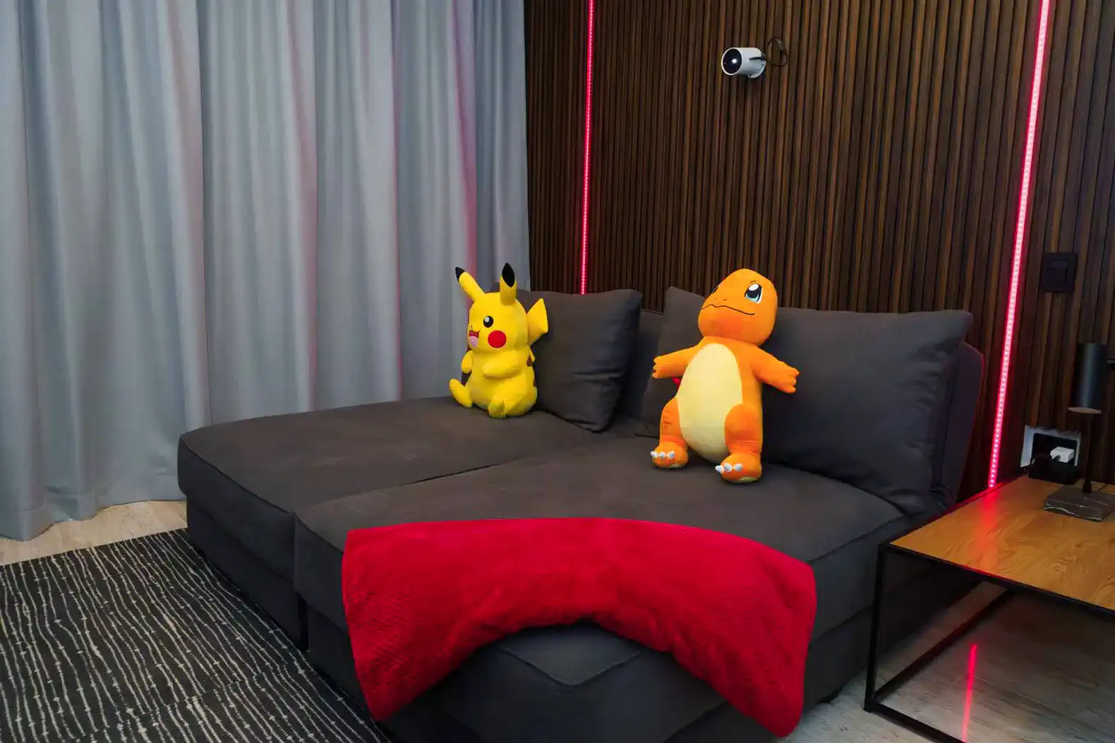 Sofá con cojines y peluches de Pikachu y Charmander en un ambiente moderno