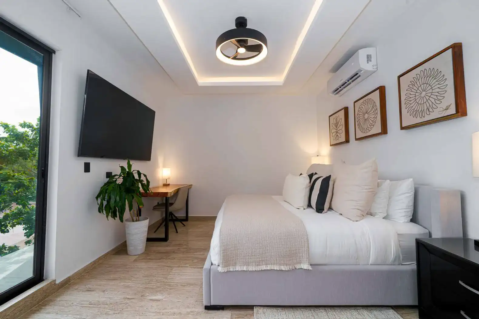 Habitación moderna con cama grande, escritorio y decoración minimalista