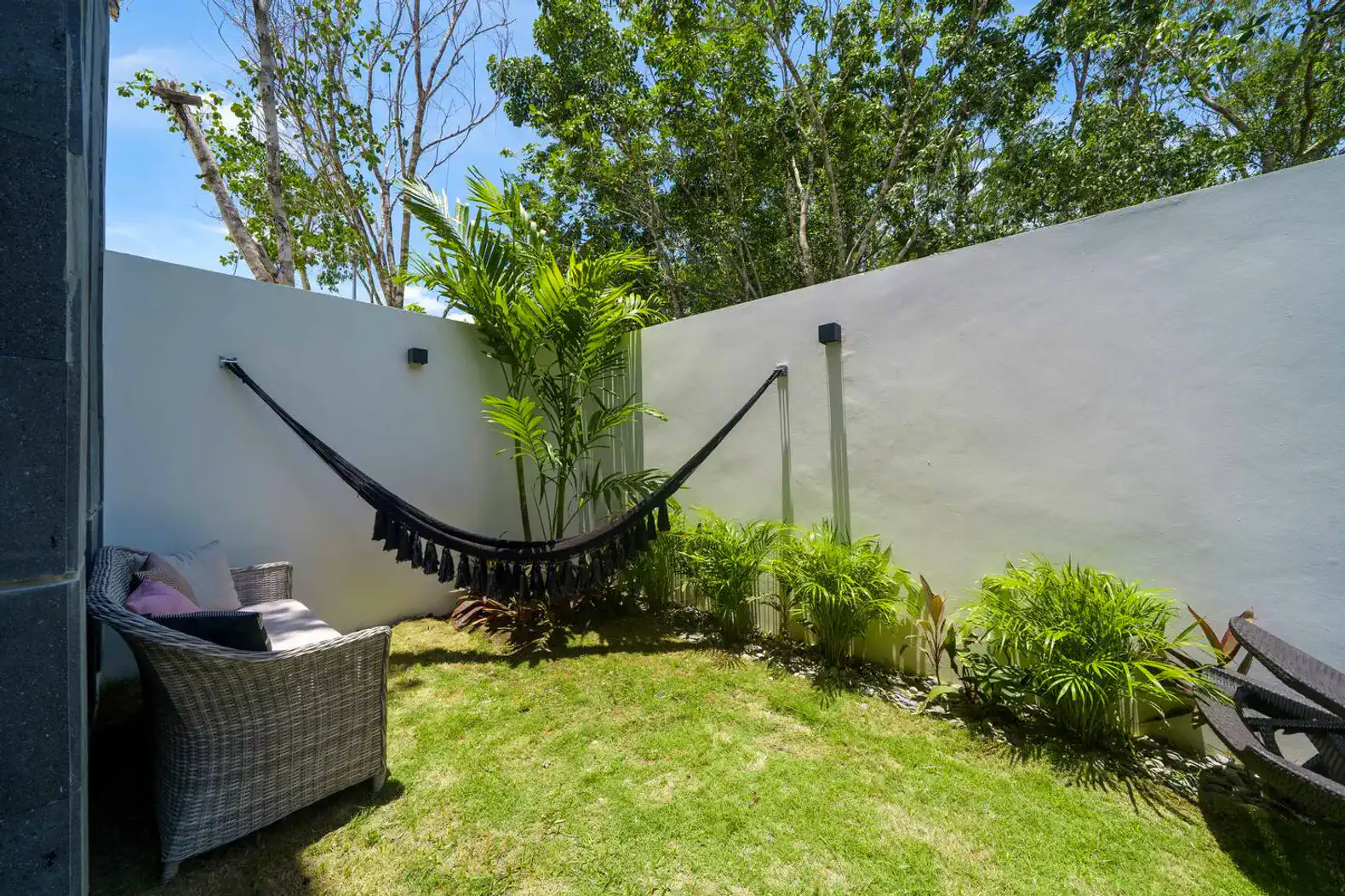 Jardín privado con hamaca y plantas tropicales