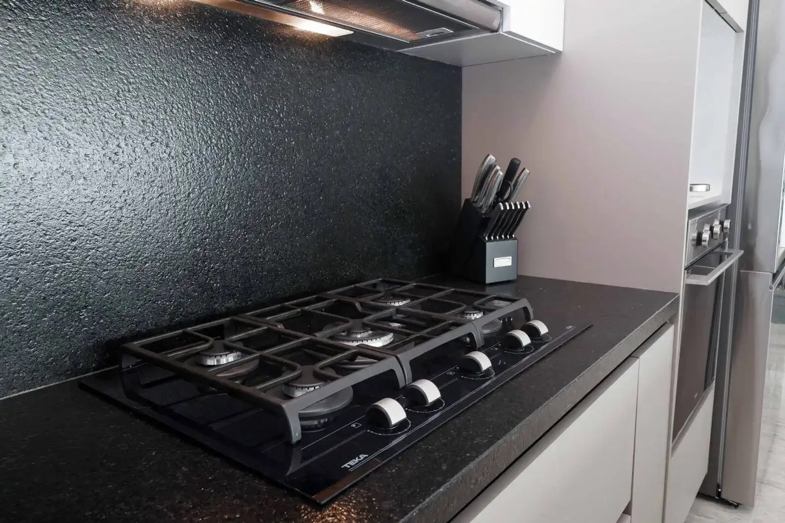 Cocina moderna con estufa de gas y utensilios de cocina organizados