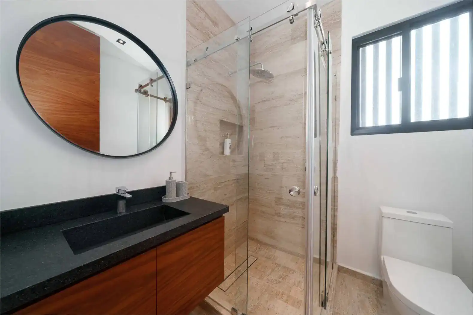 Baño moderno con ducha de vidrio y lavabo de mármol