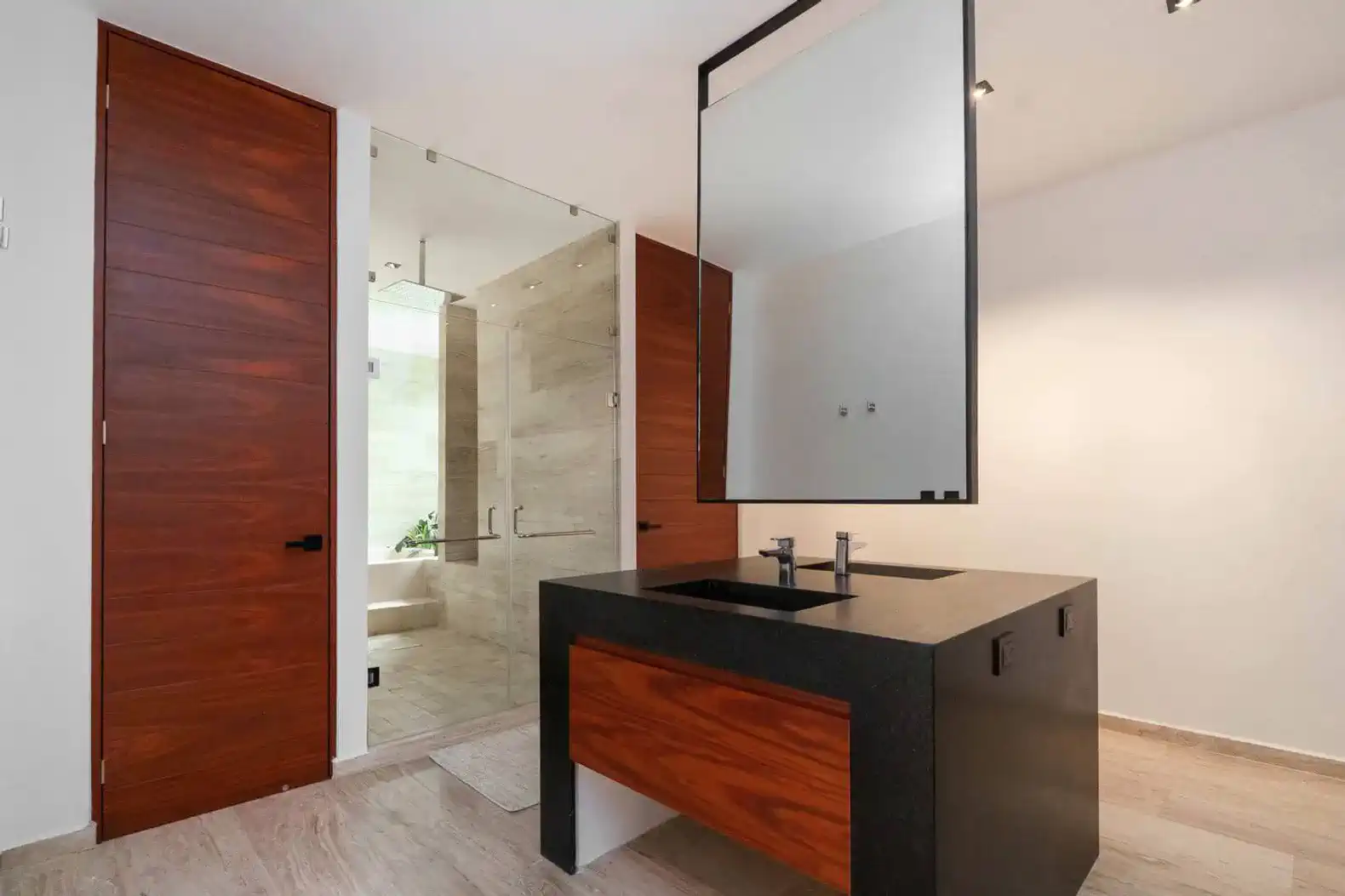 Baño moderno con lavabo de piedra y espejos grandes