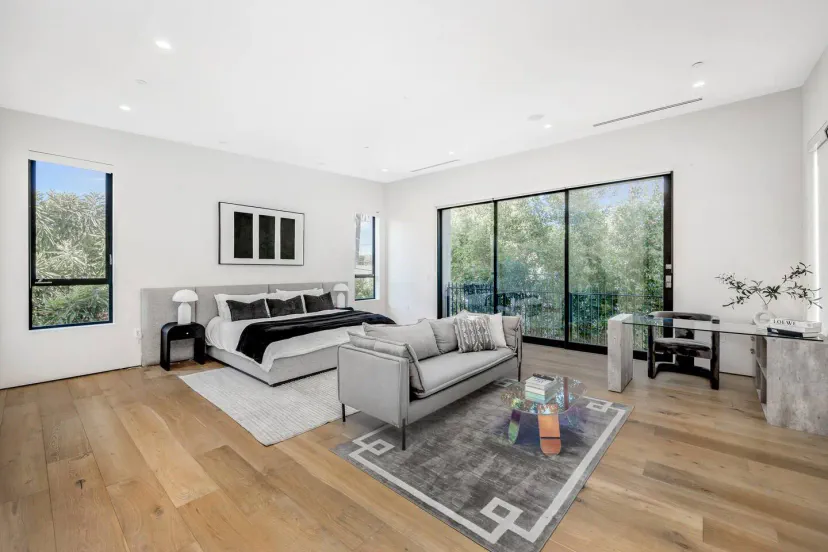 Geräumiges Hauptschlafzimmer mit großen Fenstern und modernen Möbeln