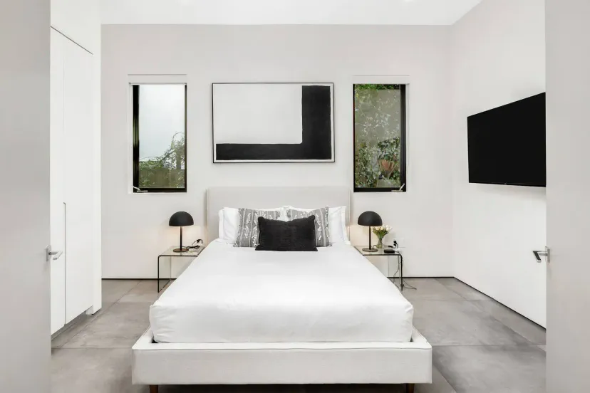 Modernes Hauptschlafzimmer mit minimalistischer Einrichtung und großen Fenstern