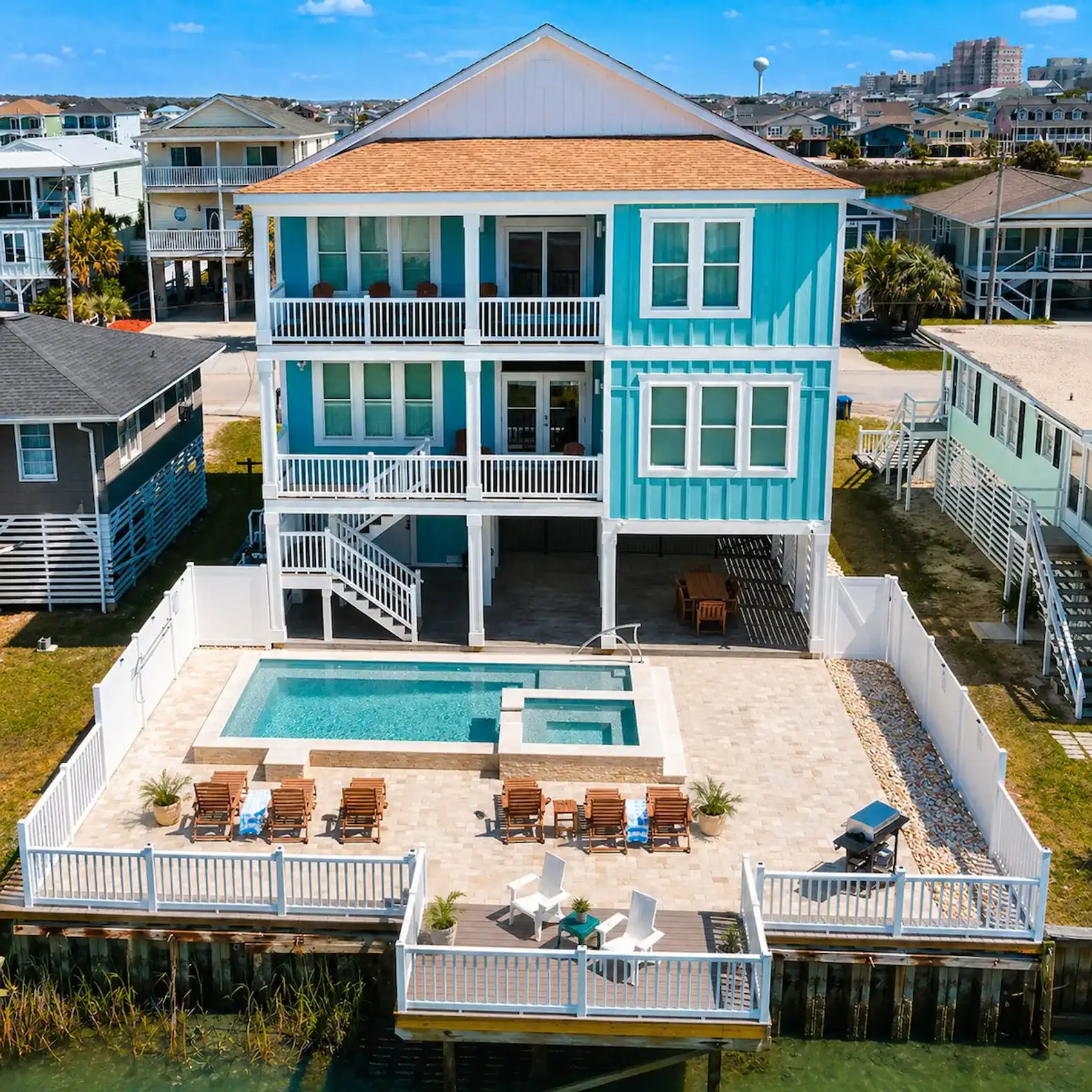 Aerial view of a beach house with a pool and outdoor seating area