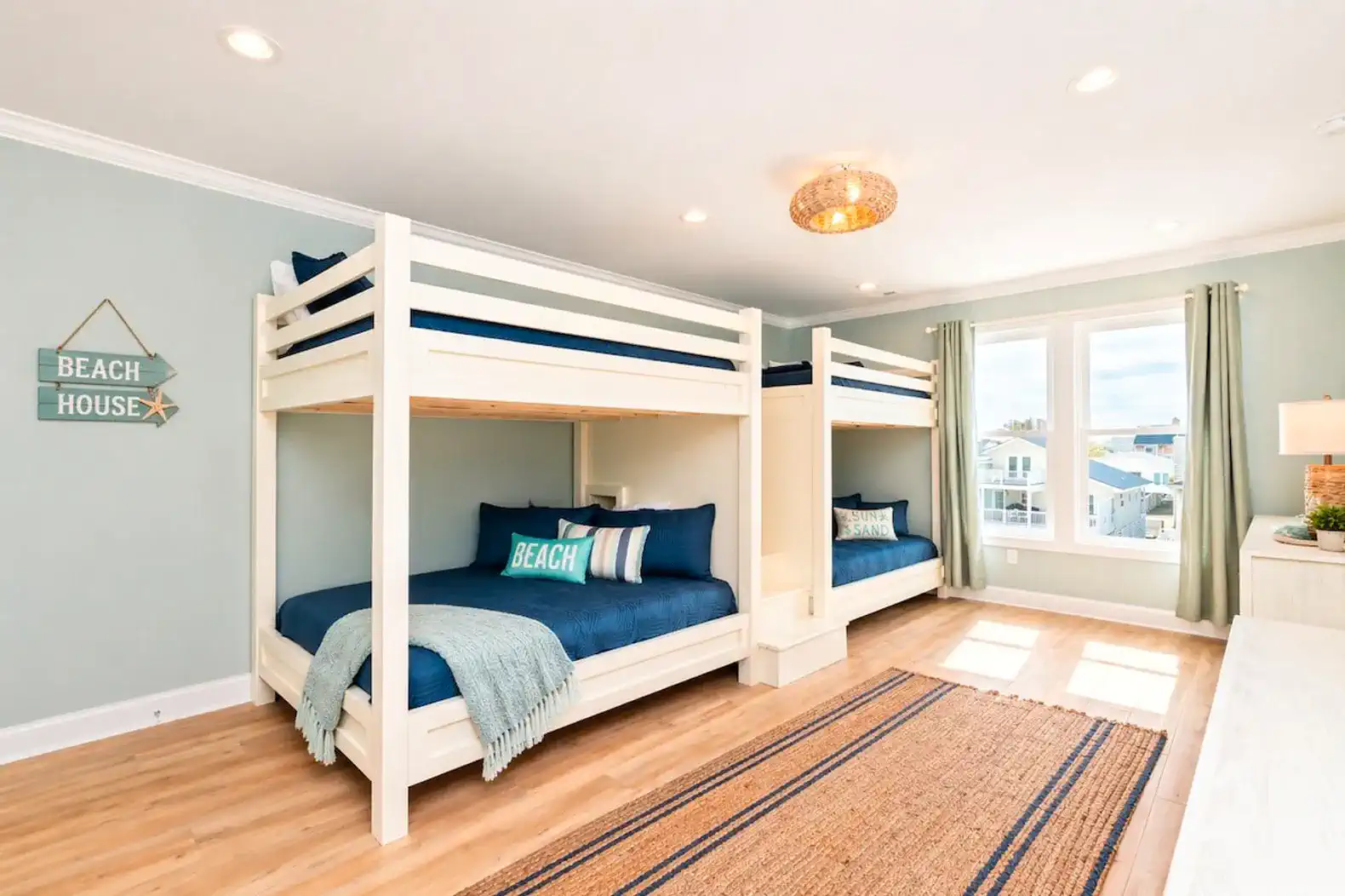 Bright and airy bunk room with two sets of bunk beds and beach-themed decor