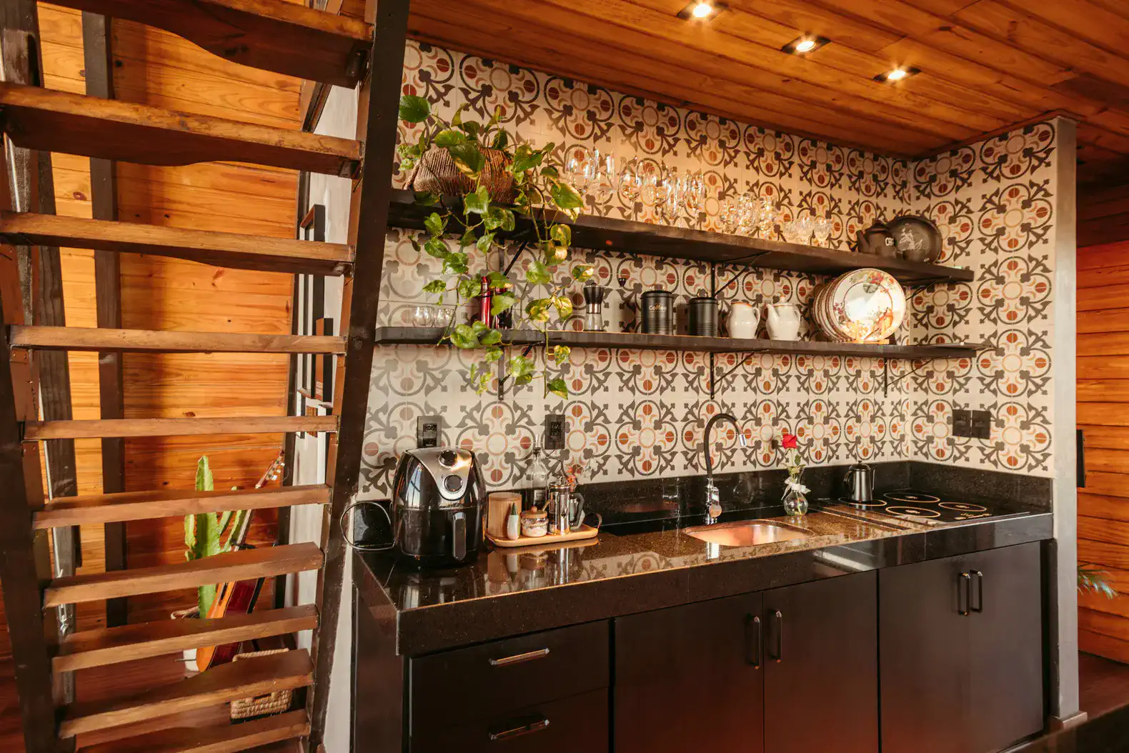 Stylish kitchen with black cabinets, patterned backsplash, and modern appliances
