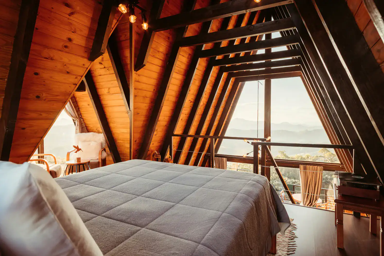 Cozy master bedroom with wooden beams and stunning mountain views