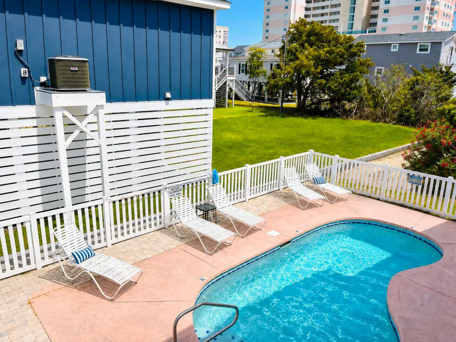 Inviting pool area with lounge chairs and fenced yard
