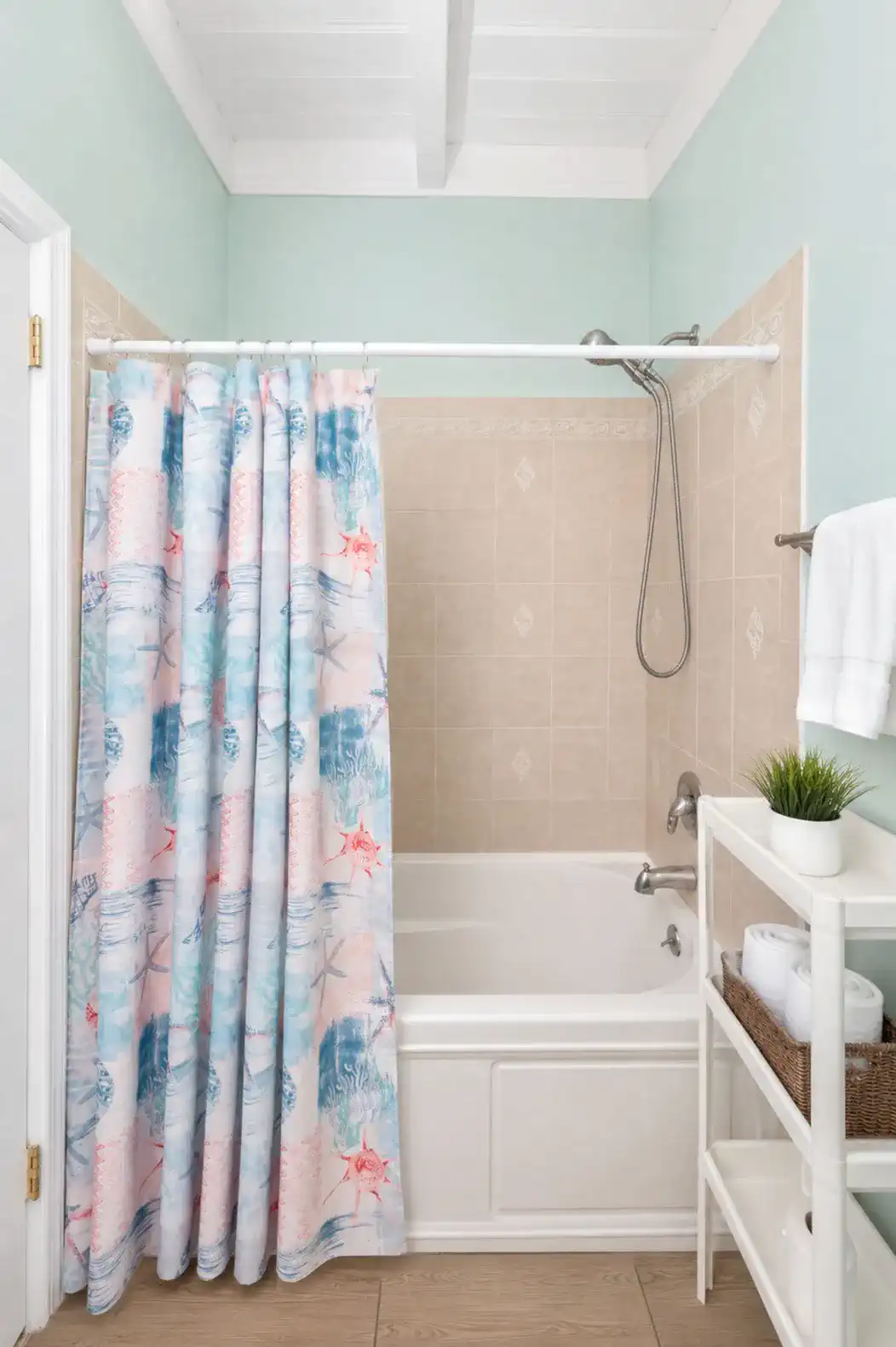 Bright bathroom featuring a tub with a colorful shower curtain and modern fixtures