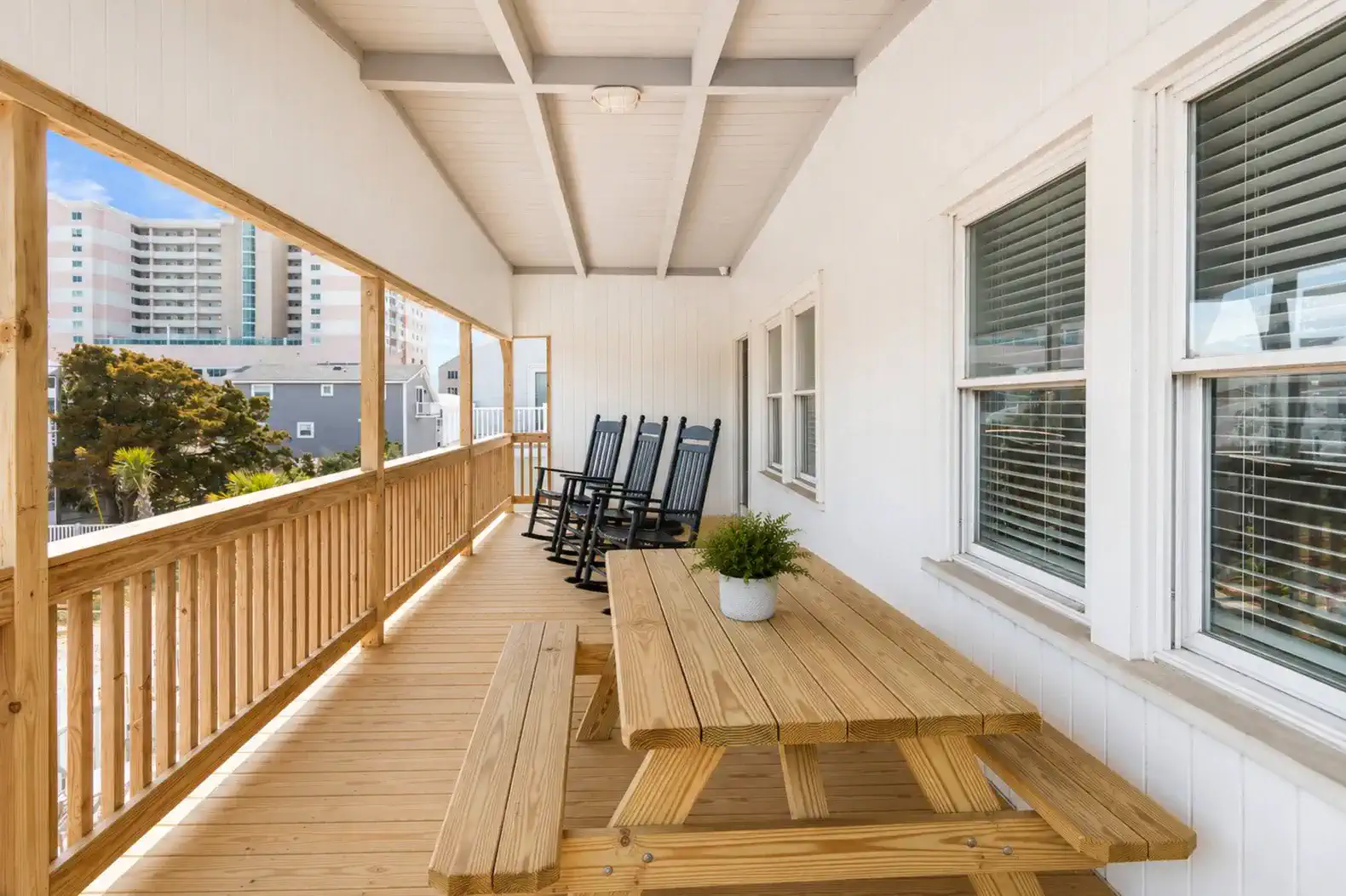 Spacious balcony with rocking chairs and a picnic table