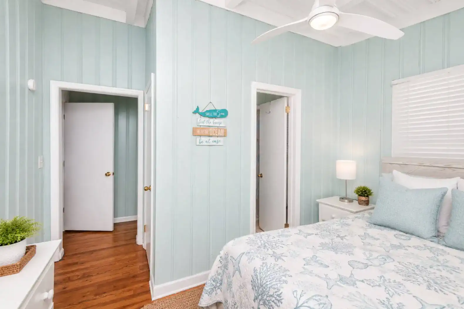 Cozy guest bedroom with light blue walls and a decorative bedspread