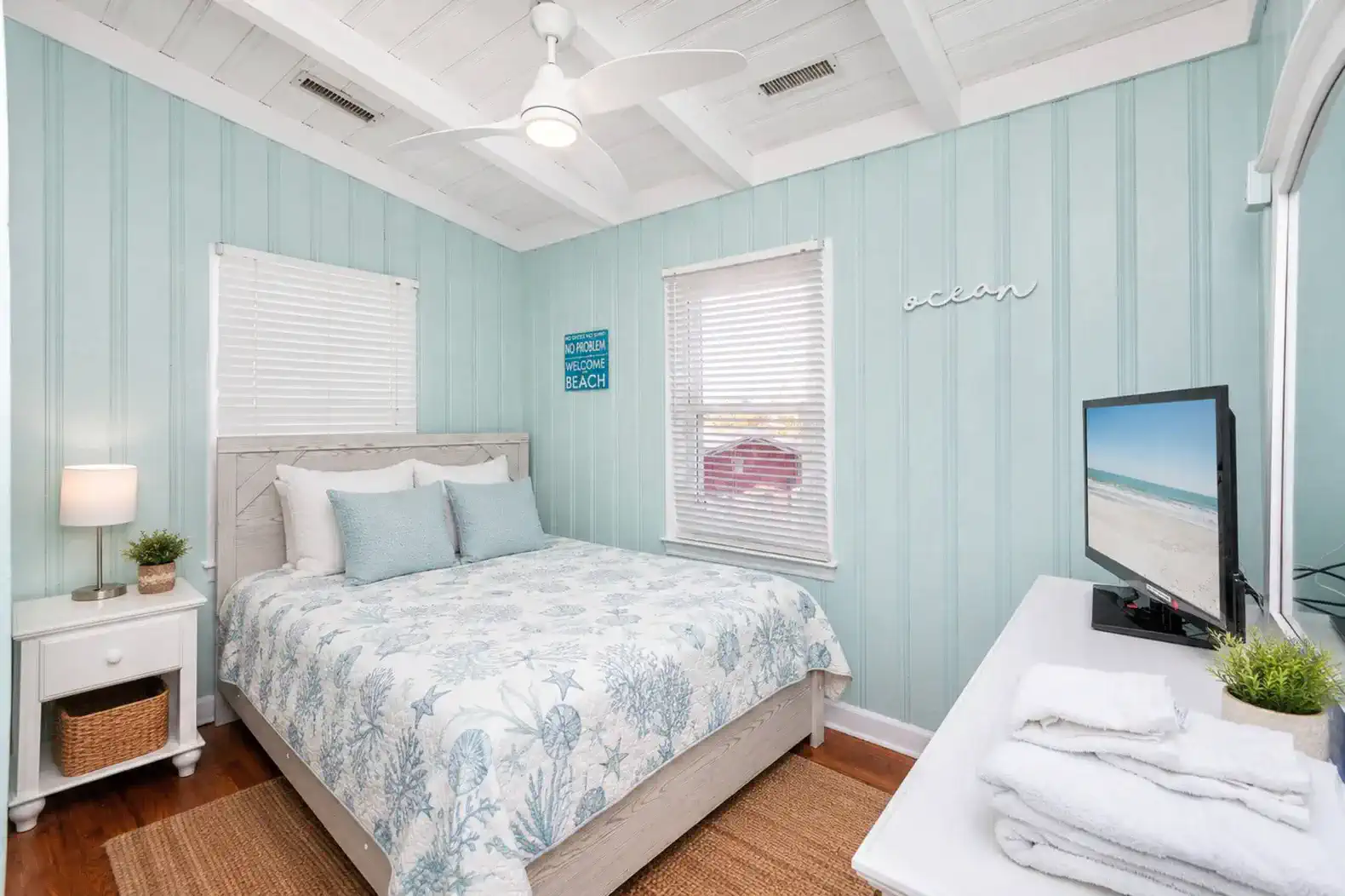 Cozy guest bedroom with beach-themed decor and a queen bed