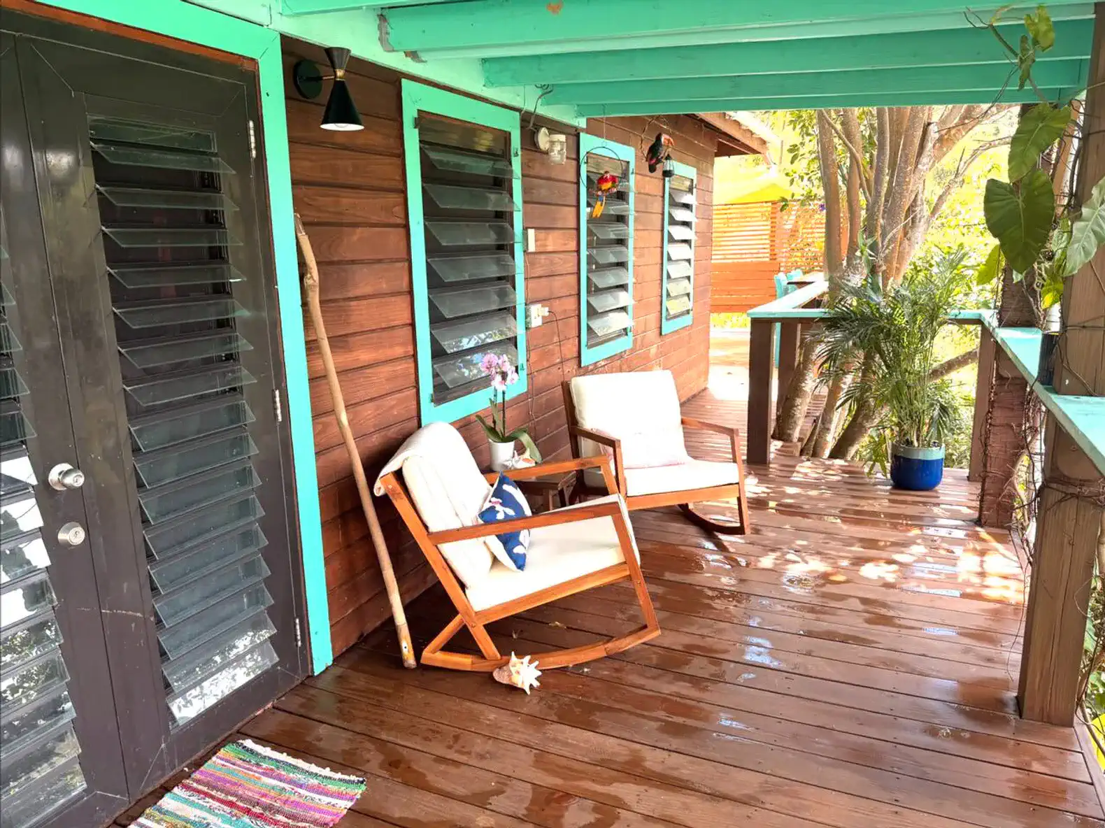 Cozy outdoor seating area with wooden chairs on a deck surrounded by greenery