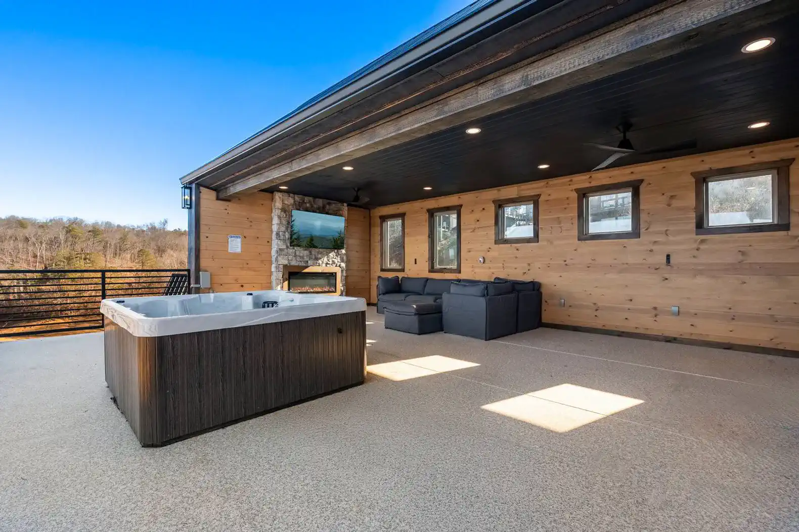 Spacious outdoor area with a hot tub and seating overlooking scenic views