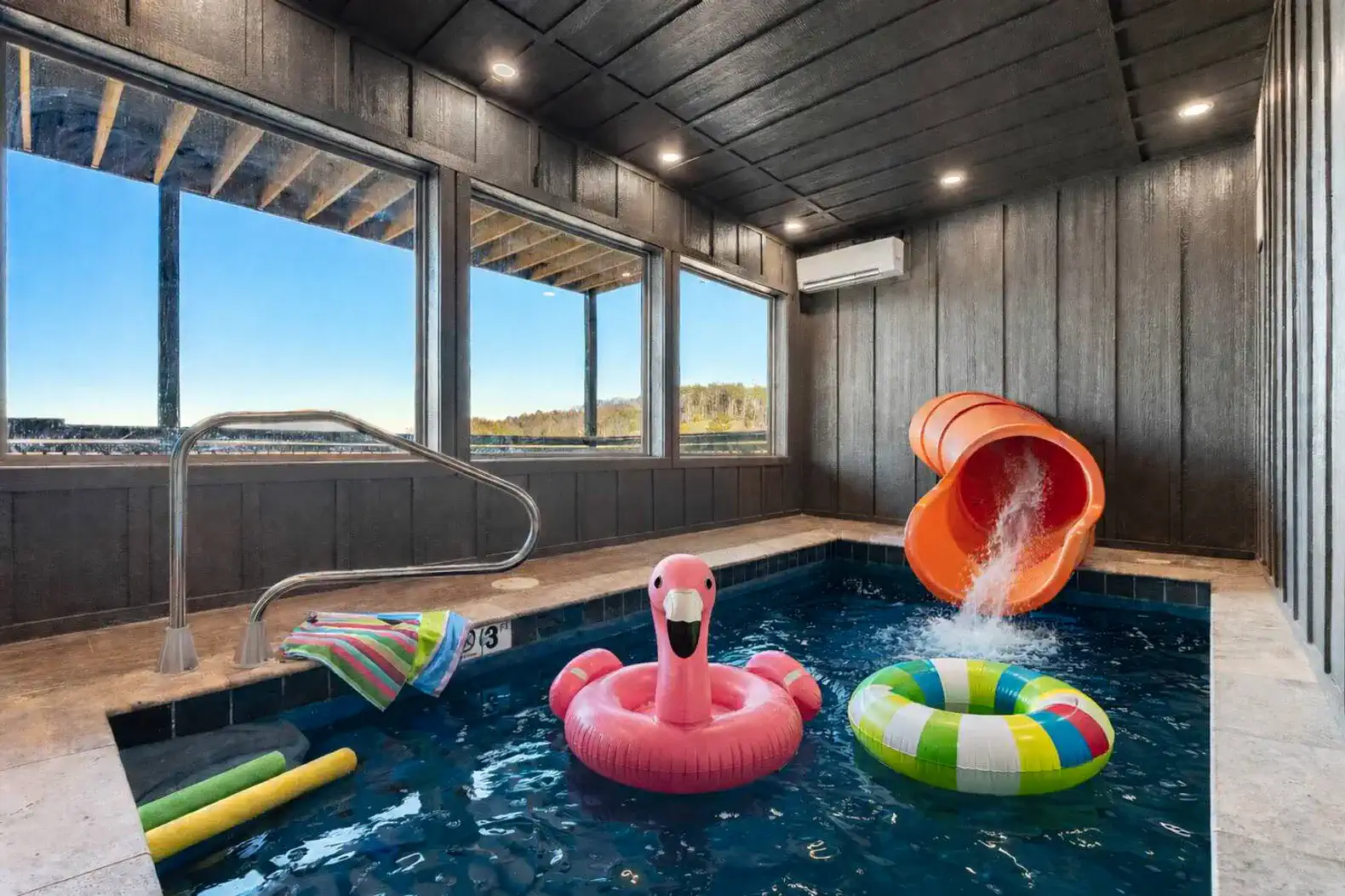 Indoor pool area featuring a water slide and colorful floats