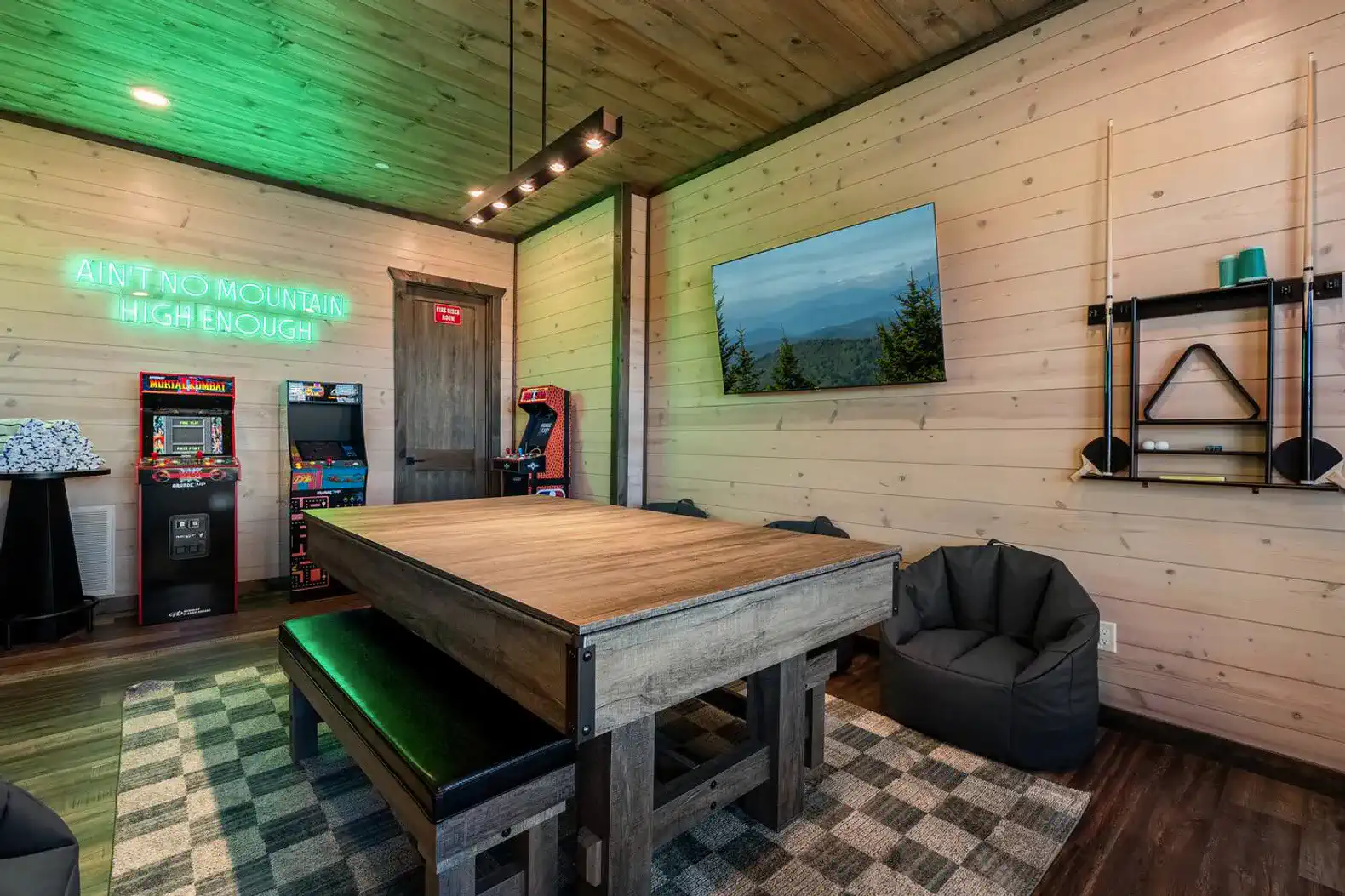Game room with arcade machines, large table, and cozy seating