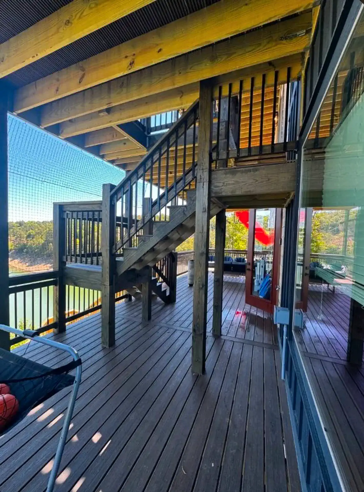 Spacious deck with stairs leading to upper level and views of the lake
