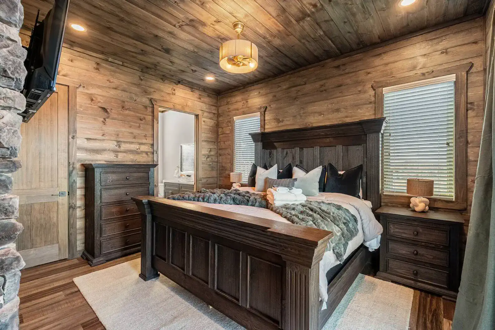 Cozy master bedroom with wooden walls, large bed, and stylish decor