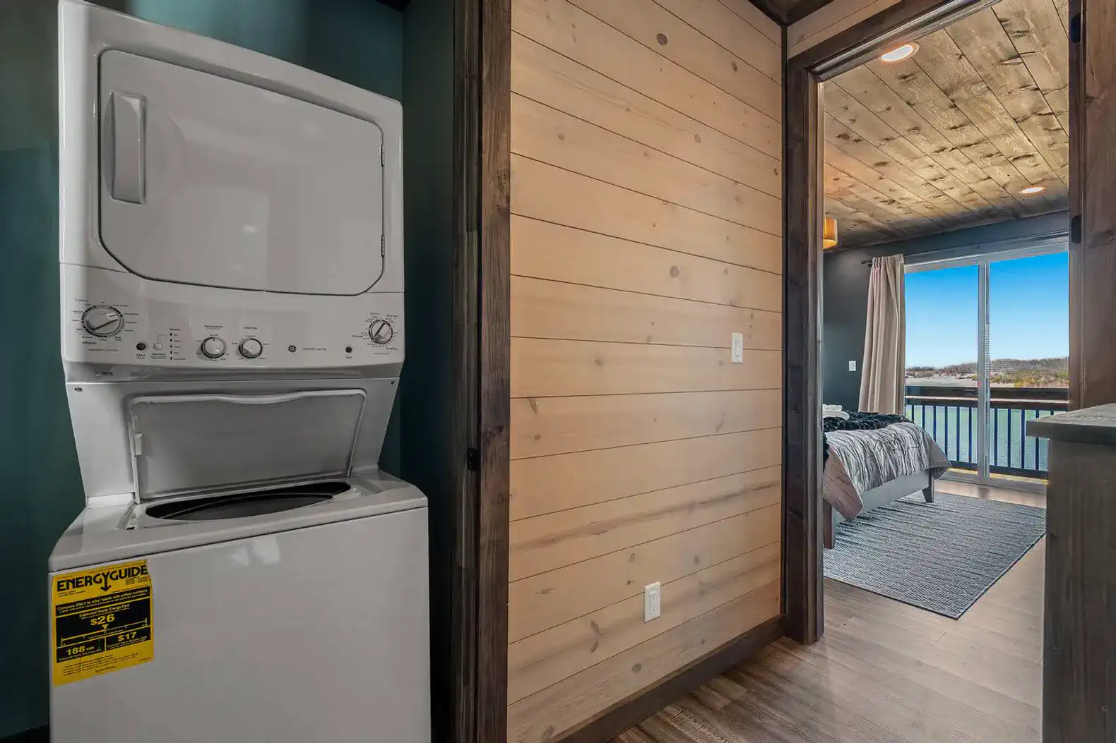 Washer and dryer in a cozy laundry nook near a bedroom with lake views