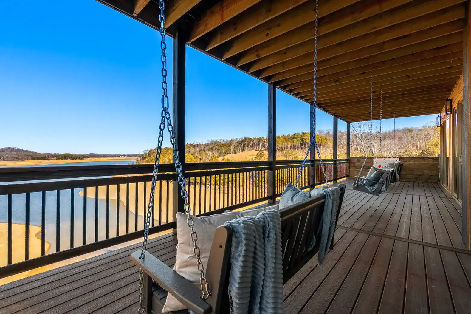 Spacious deck with swings overlooking the lake and surrounding nature