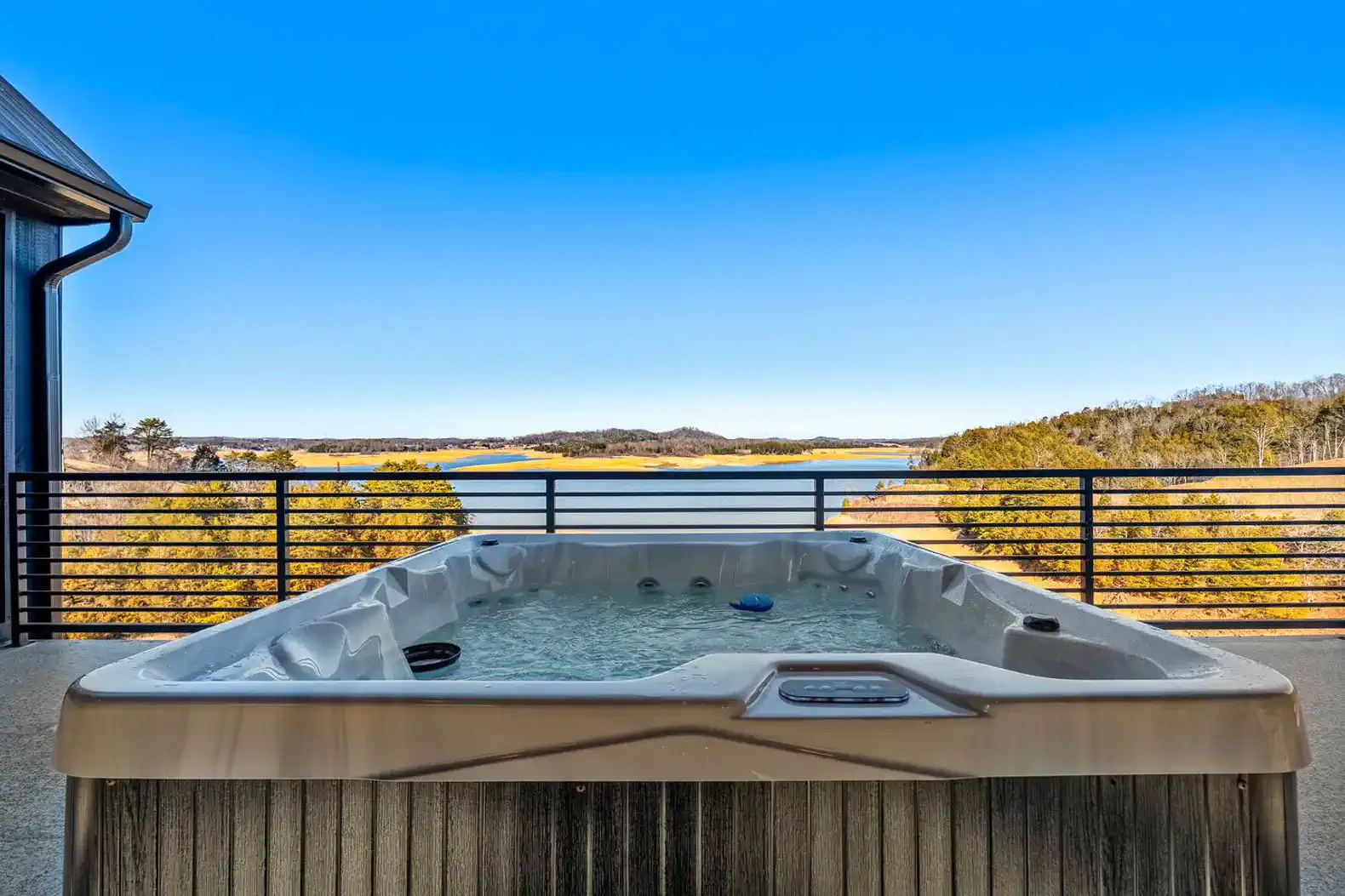 Hot tub with scenic lake views and clear blue sky