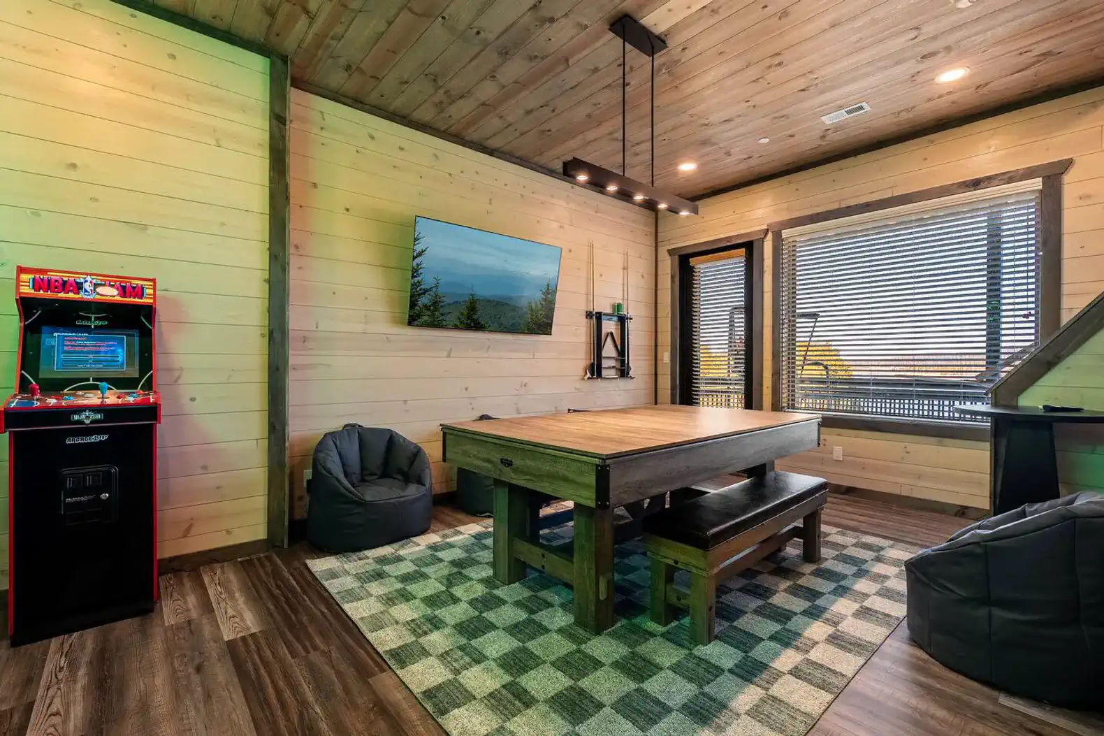 Cozy game room with arcade machine, large table, and bean bags