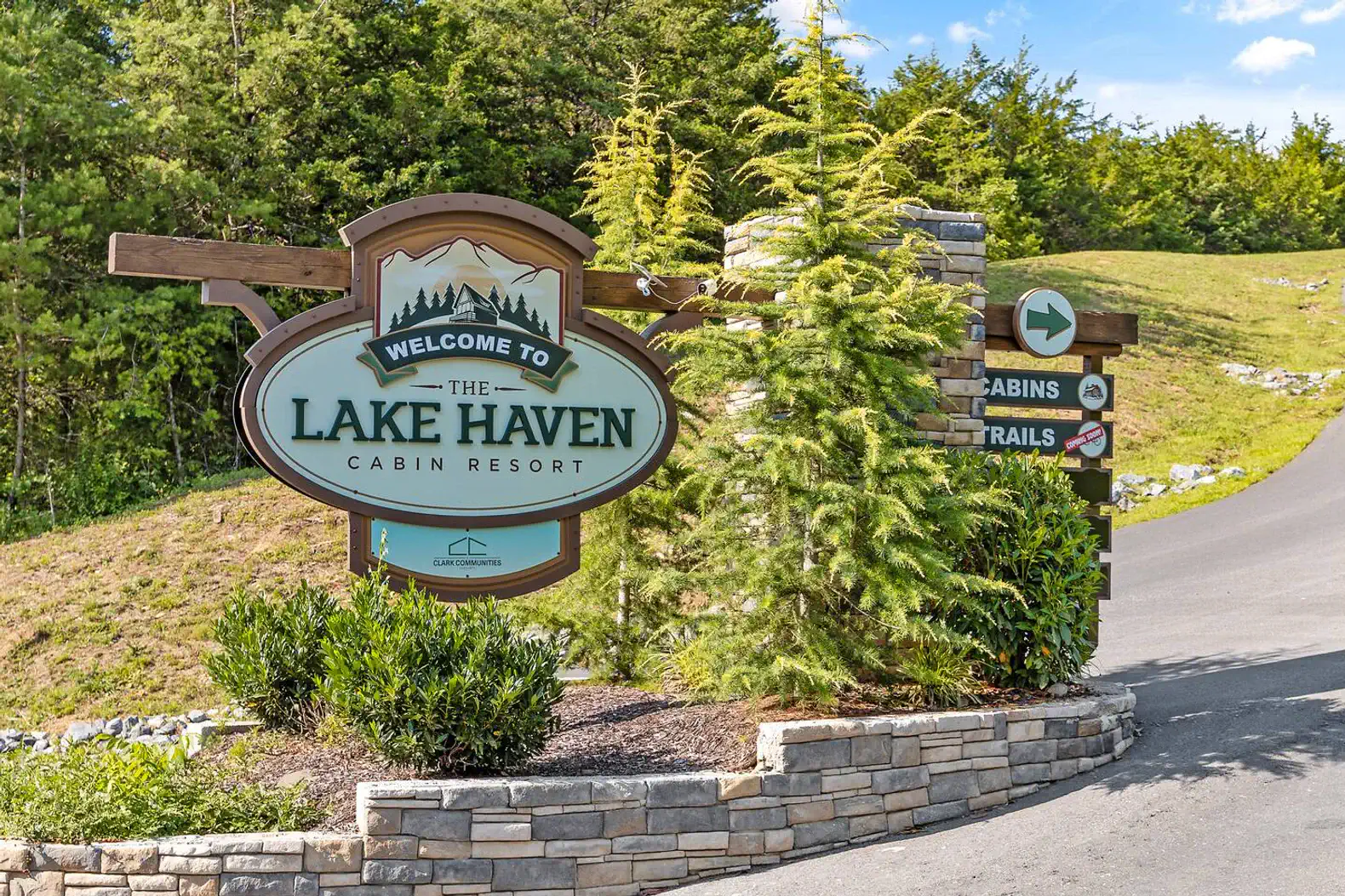 Welcome sign for Lake Haven Cabin Resort with greenery and stone features