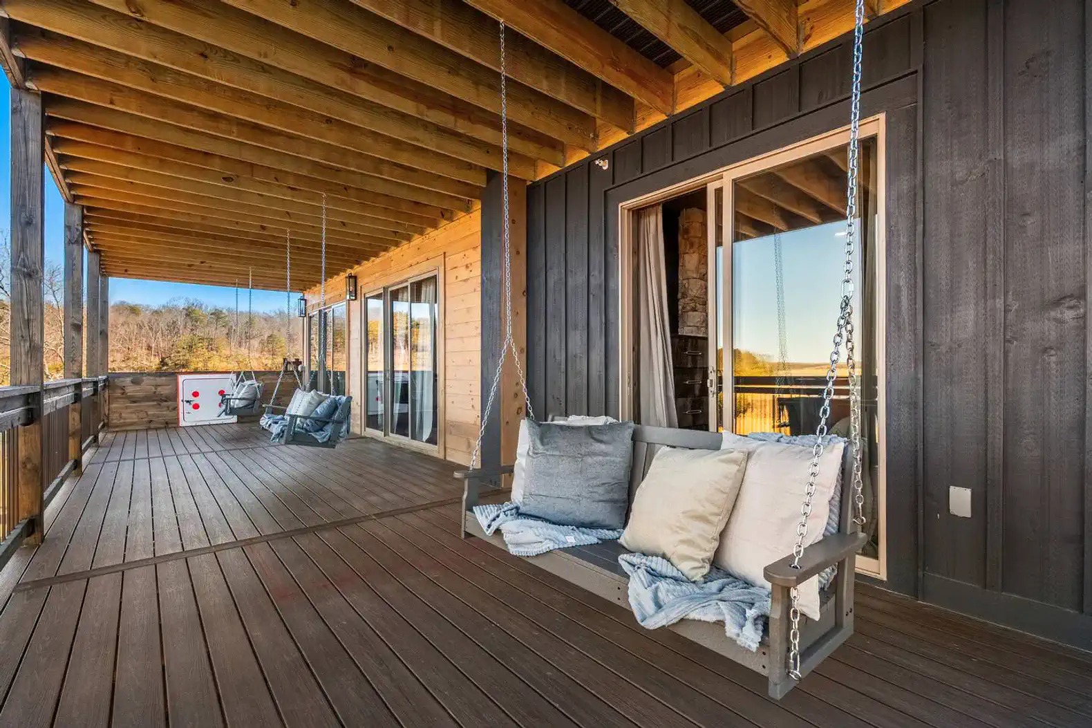 Spacious outdoor deck with swing seating and scenic views