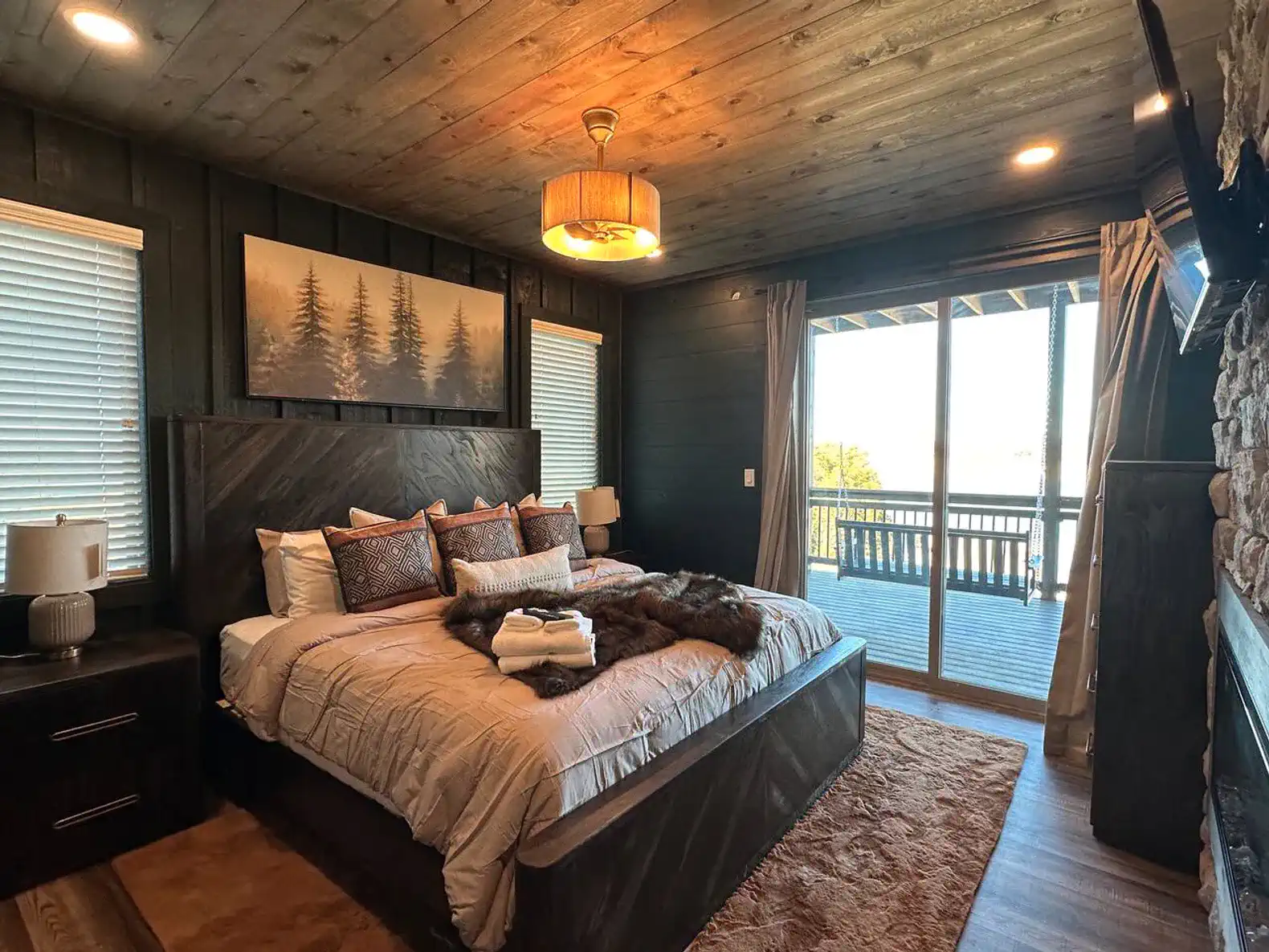 Cozy master bedroom with lake views, large bed, and sliding door to balcony