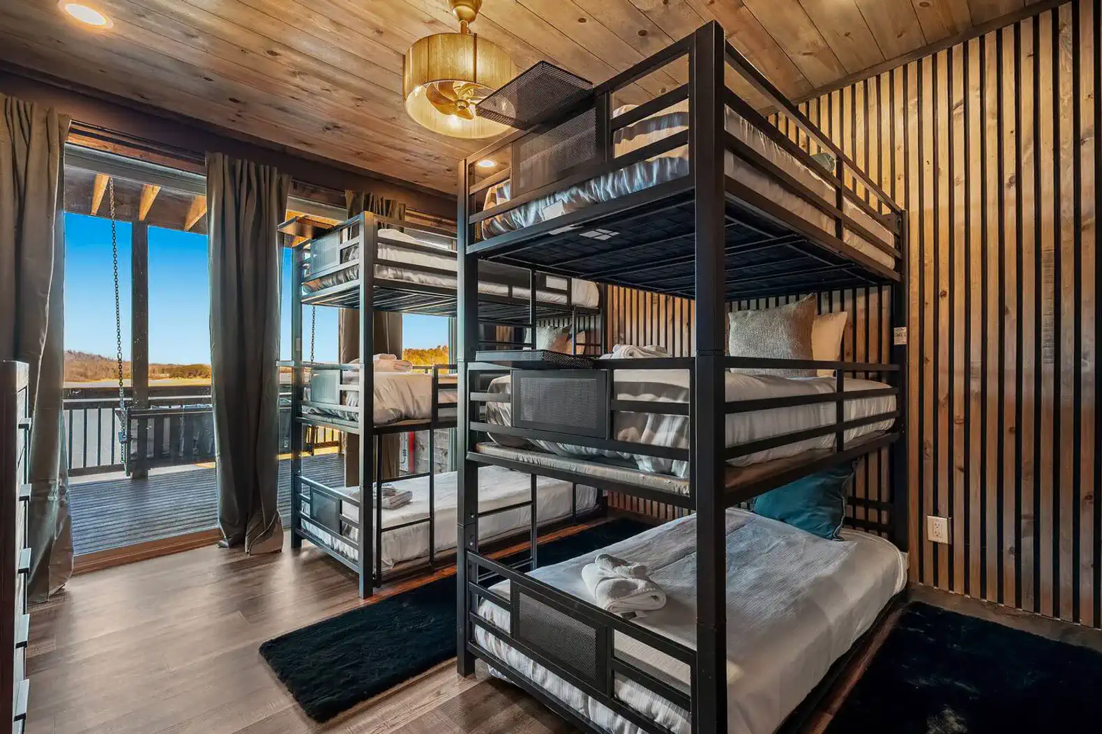 Bunk room with metal bunk beds and large windows overlooking the lake